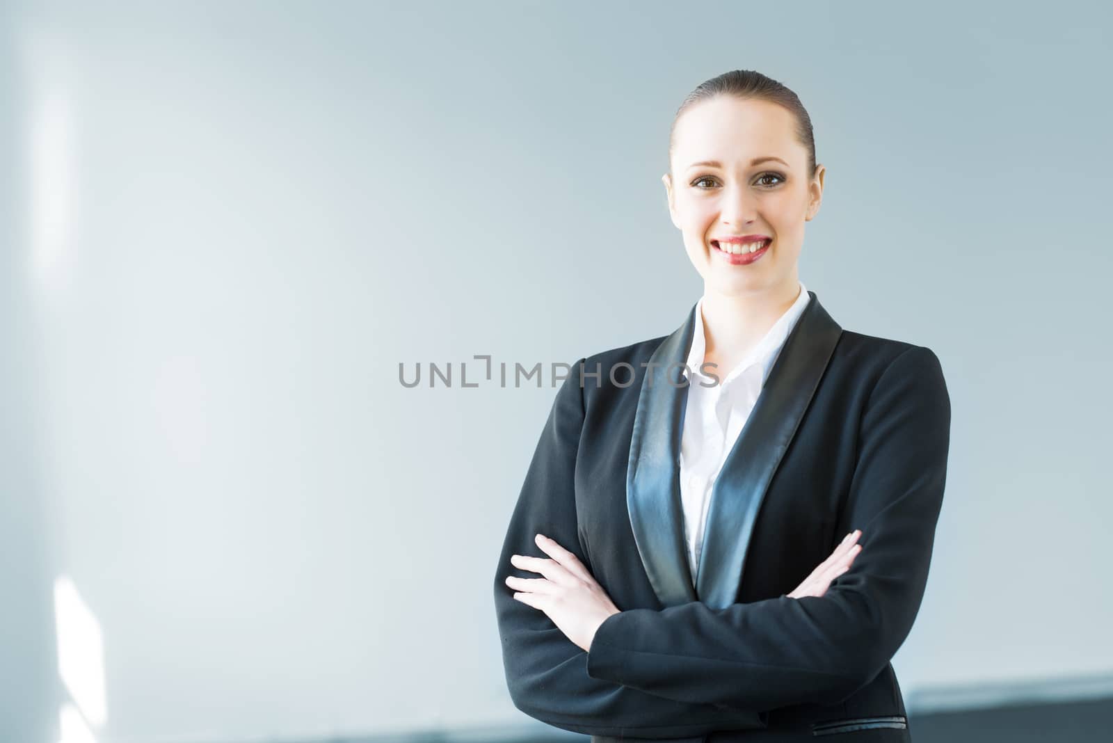 young modern business woman, crossed her arms and smiles