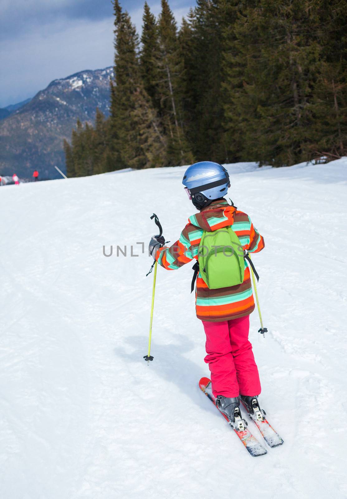 Girl on skis in soft snow in the mountains