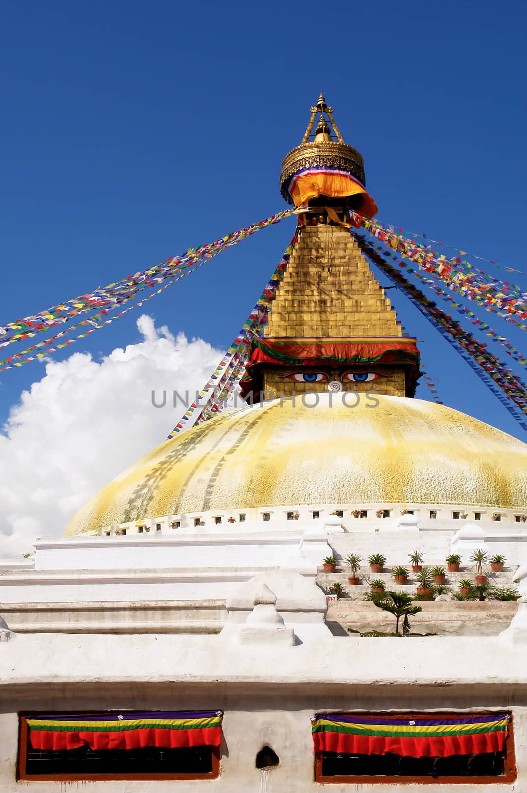 stupa with buddha eyes and prayer flags on clear blue sky backgr by ptxgarfield