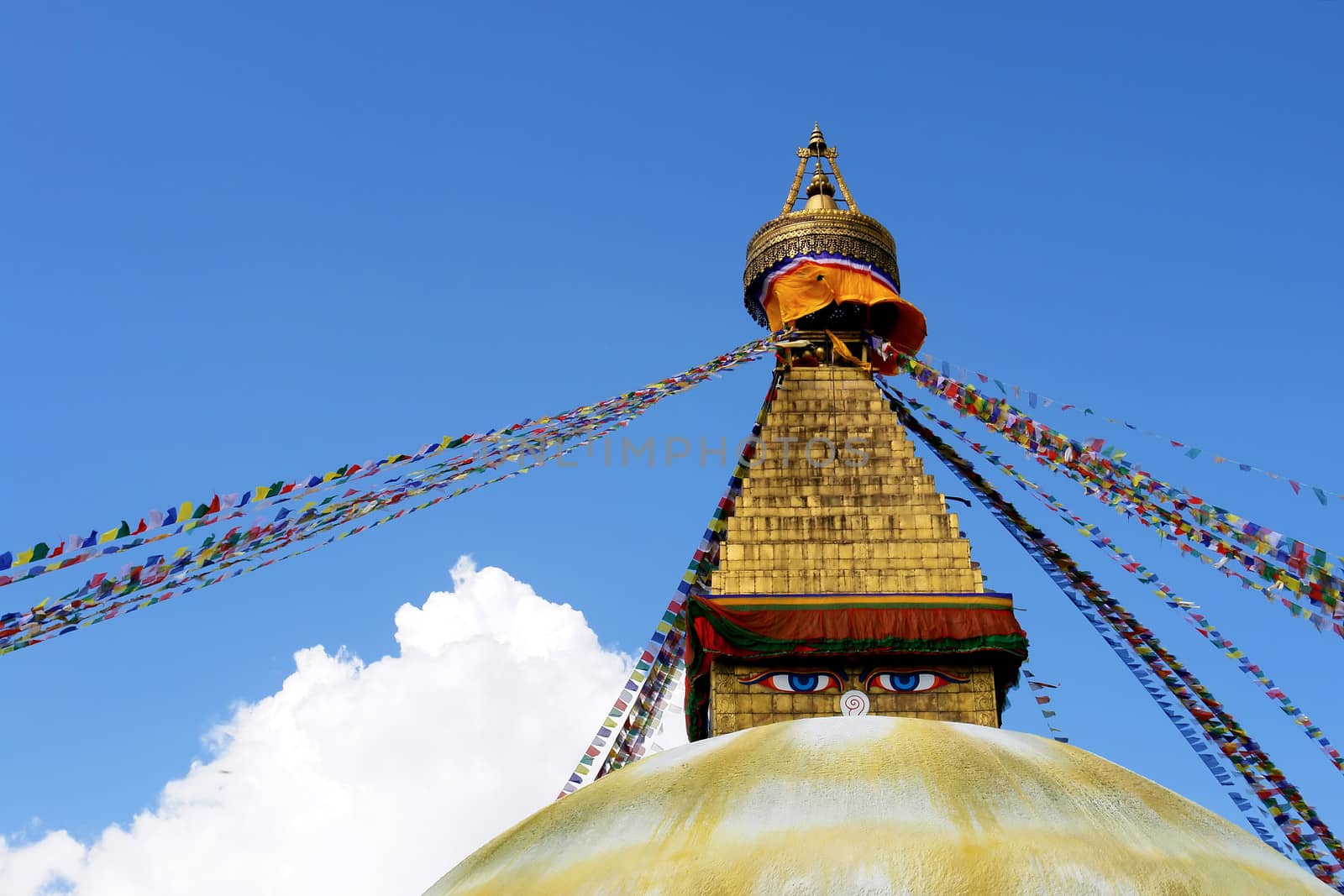 stupa with buddha eyes and prayer flags on clear blue sky backgr by ptxgarfield