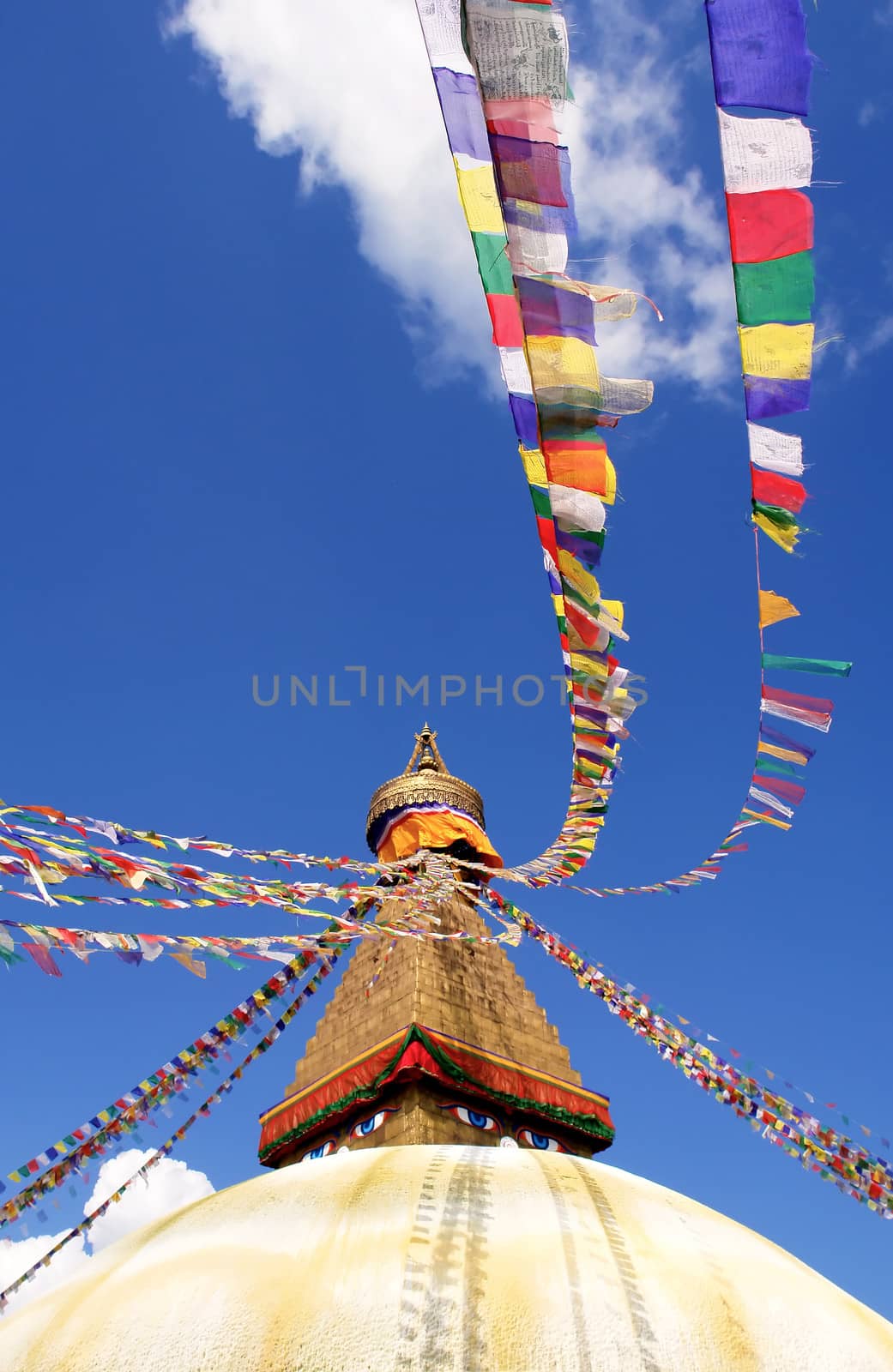 bodhnath stupa in kathmandu with buddha eyes and prayer flags on clear blue sky background