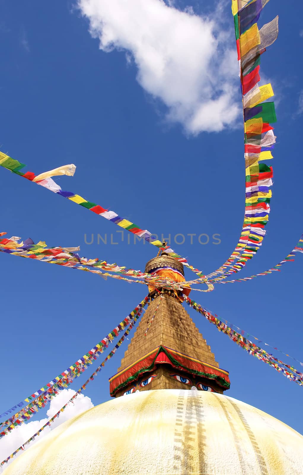 stupa with buddha eyes and prayer flags on clear blue sky backgr by ptxgarfield