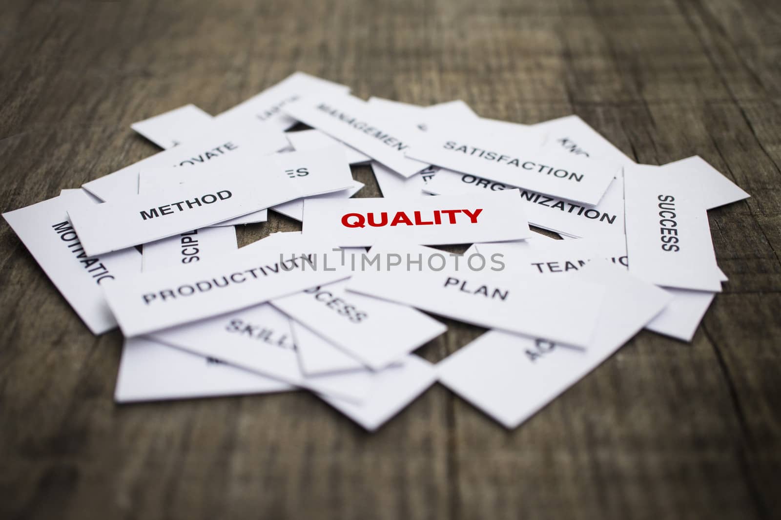 Paper strips with Quality related words on wooden background