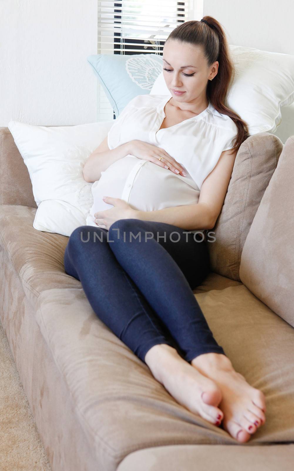 Beautiful young pregnant woman lying on the sofa