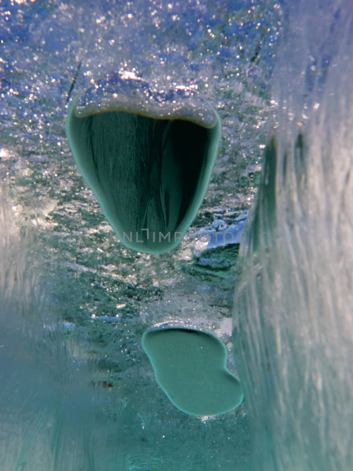 Air bubbles trapped under frozen ice surface mysterious underwater abstract