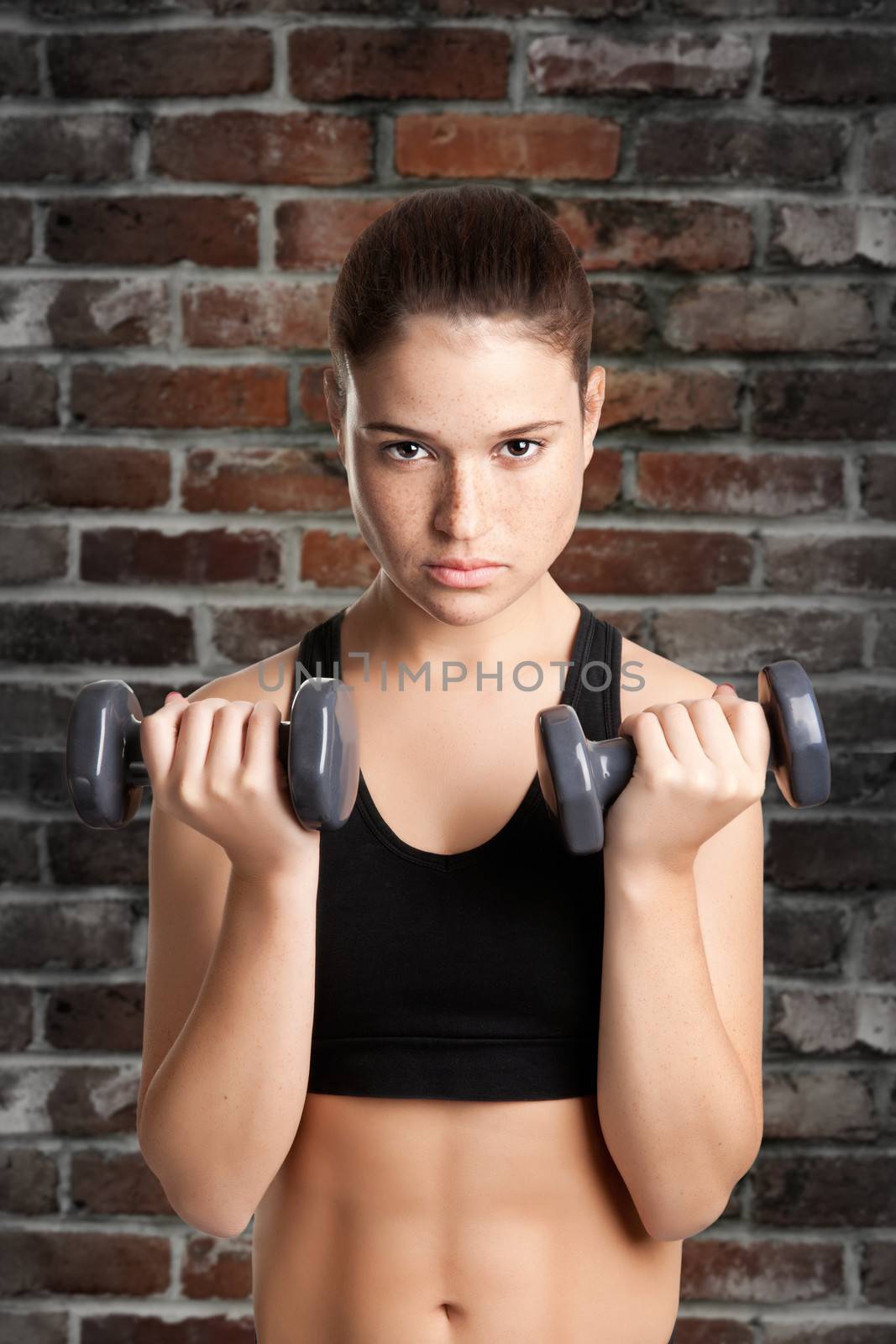 Woman working out with dumbbells at a gym