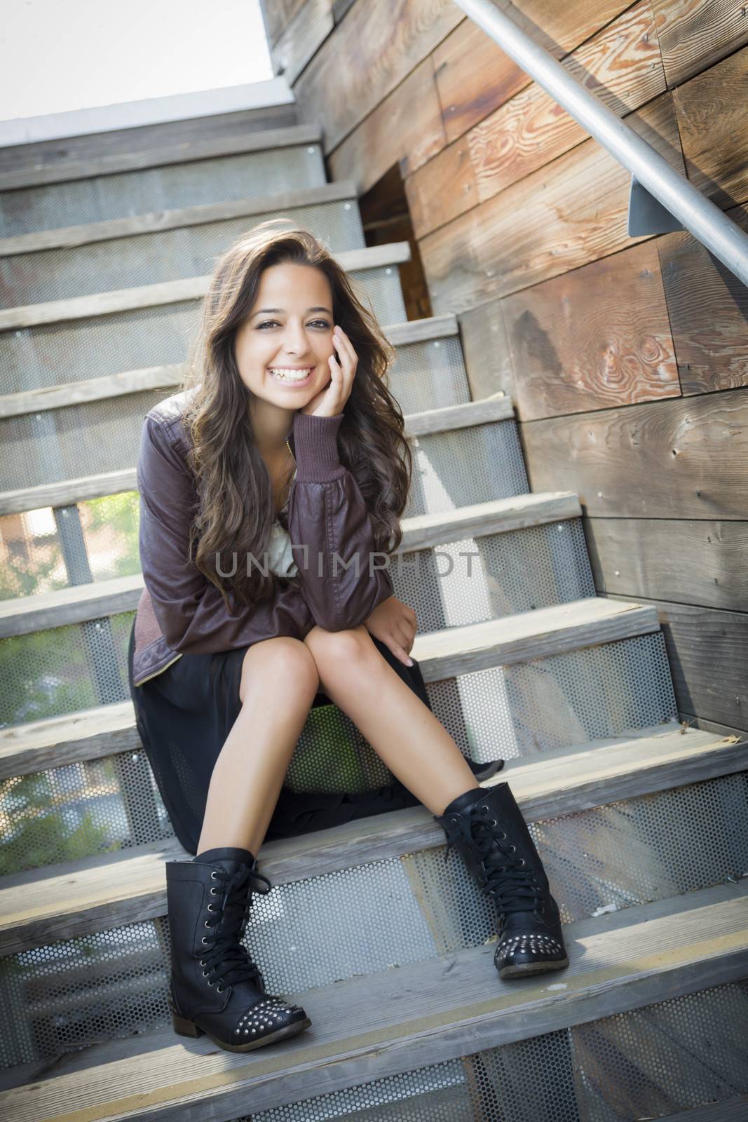 Portrait of a Pretty Mixed Race Young Adult Woman Sitting on a Staircase Wearing Leather Boots and Jacket.