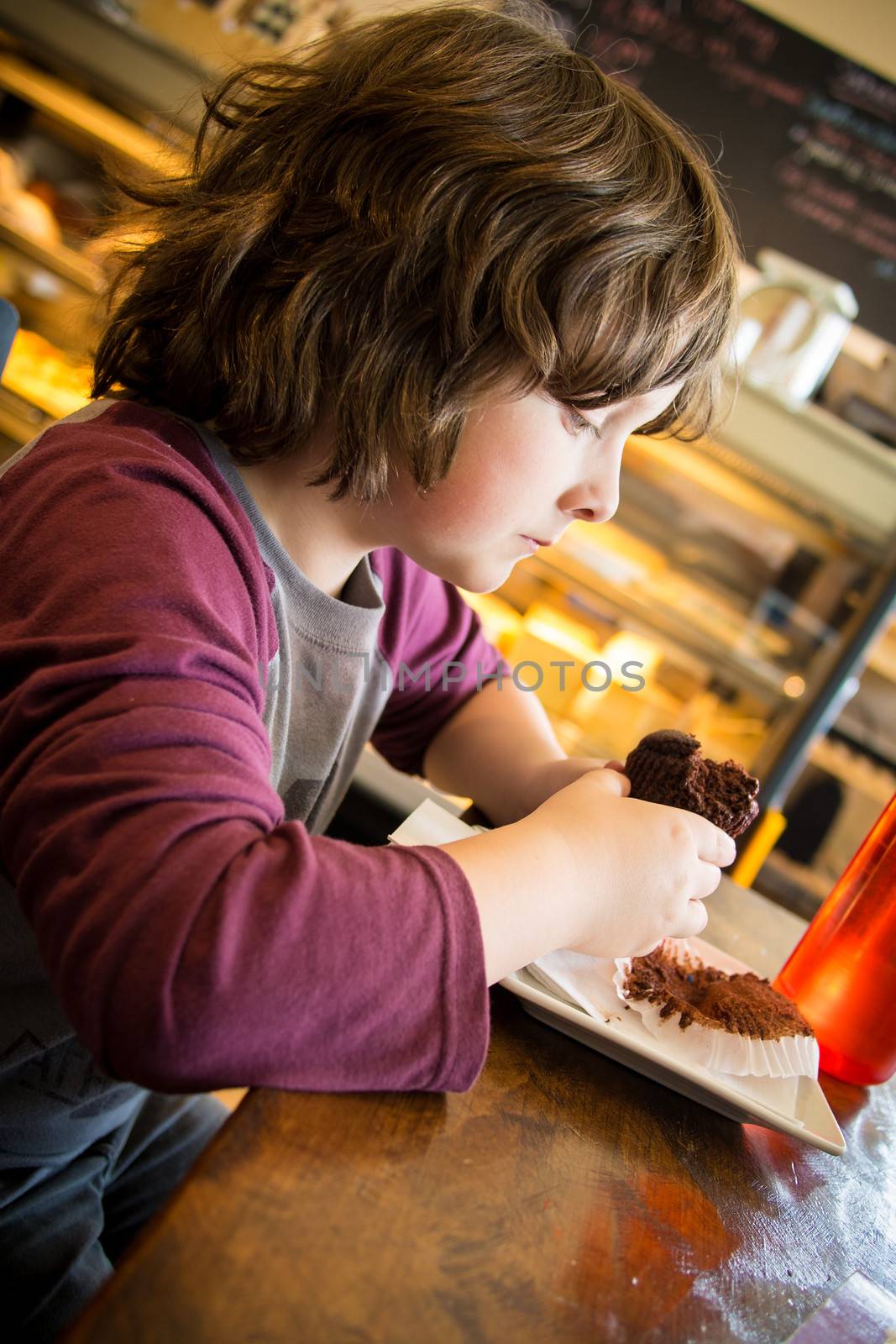 Boy eating a cupcake in a restaurant