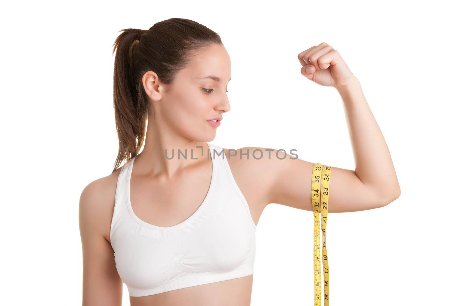 Powerful woman measuring her biceps with a yellow measuring tape