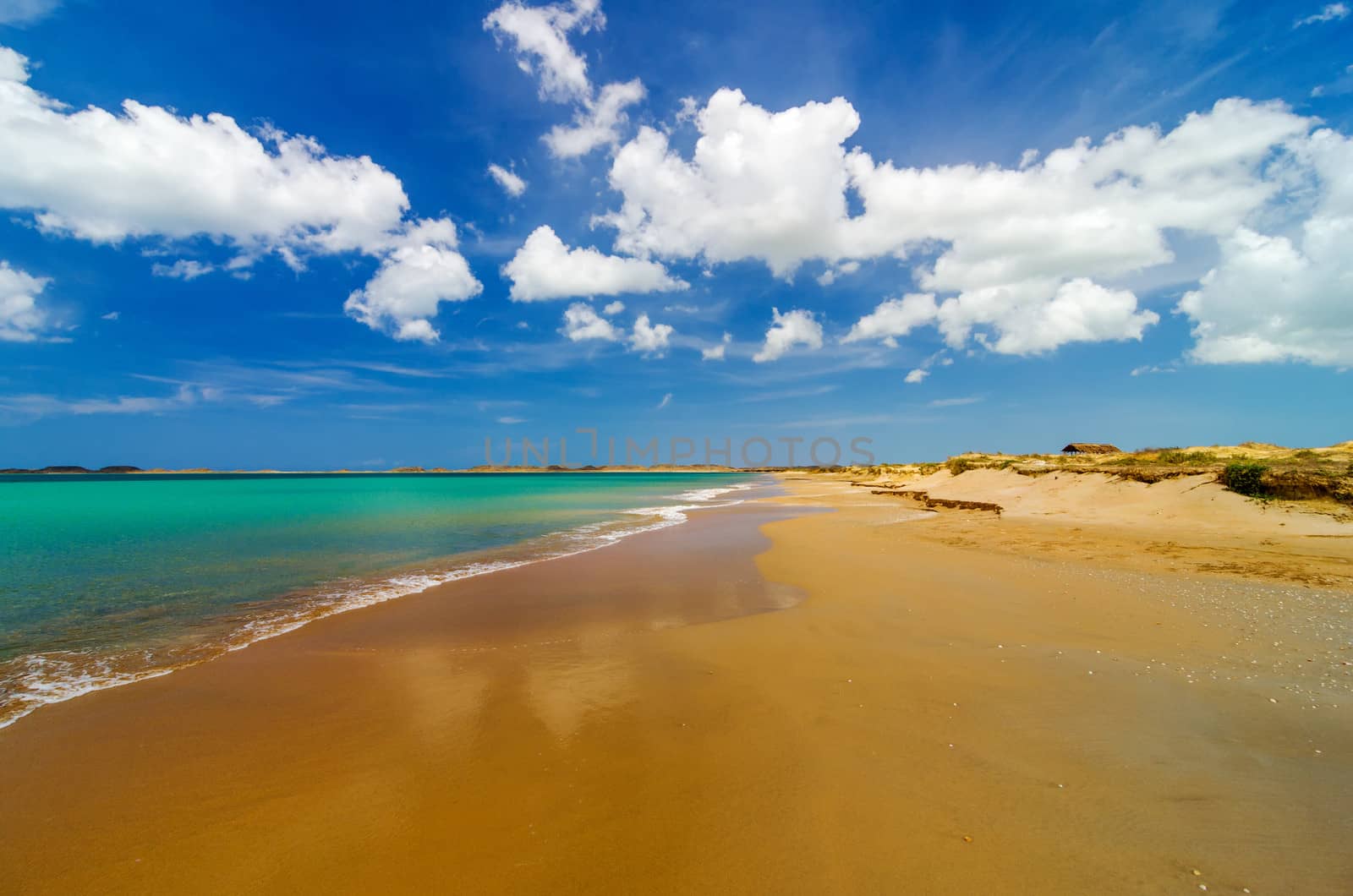 Wide deserted beach with turquoise Caribbean water in La Guajira, Colombia