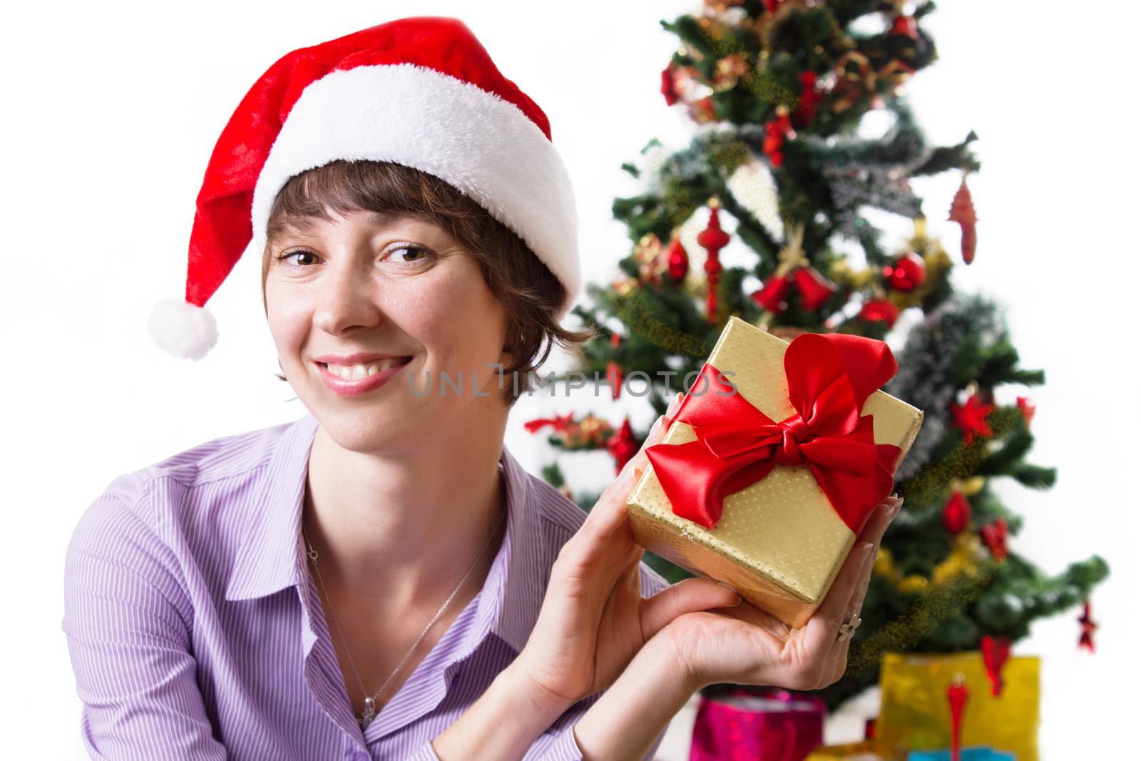 Woman in Santa hat with present under Cristmas tree by Angel_a
