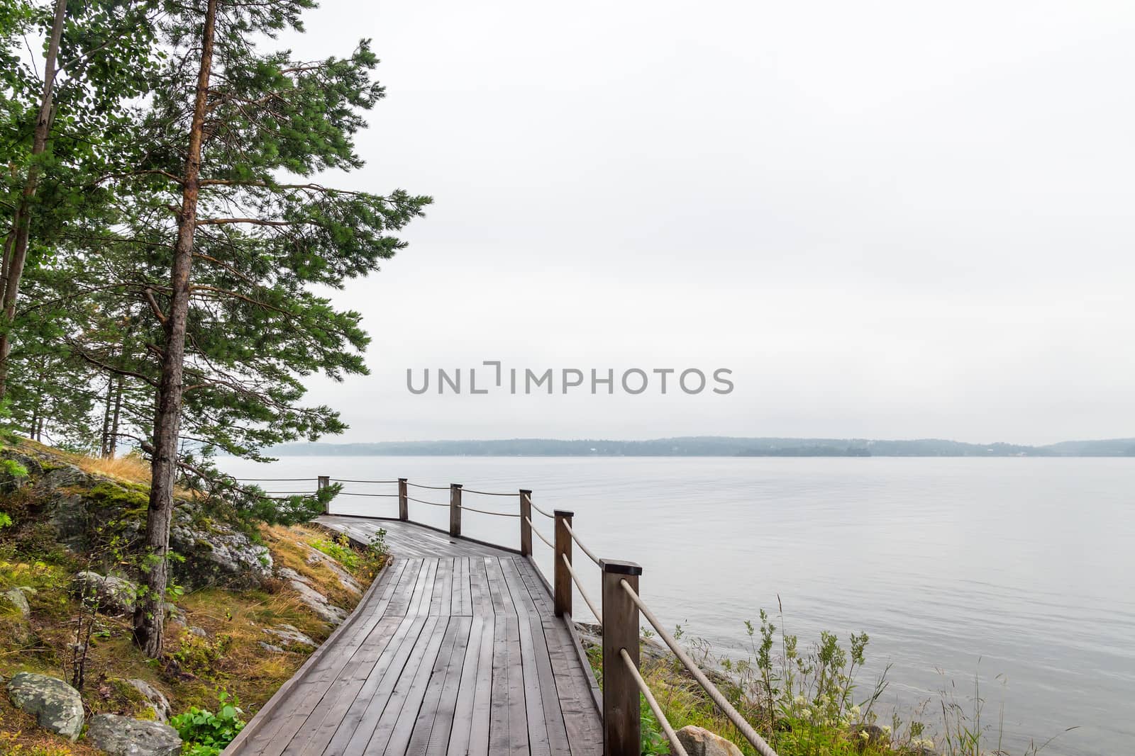 Wooden path going along the calm lake.