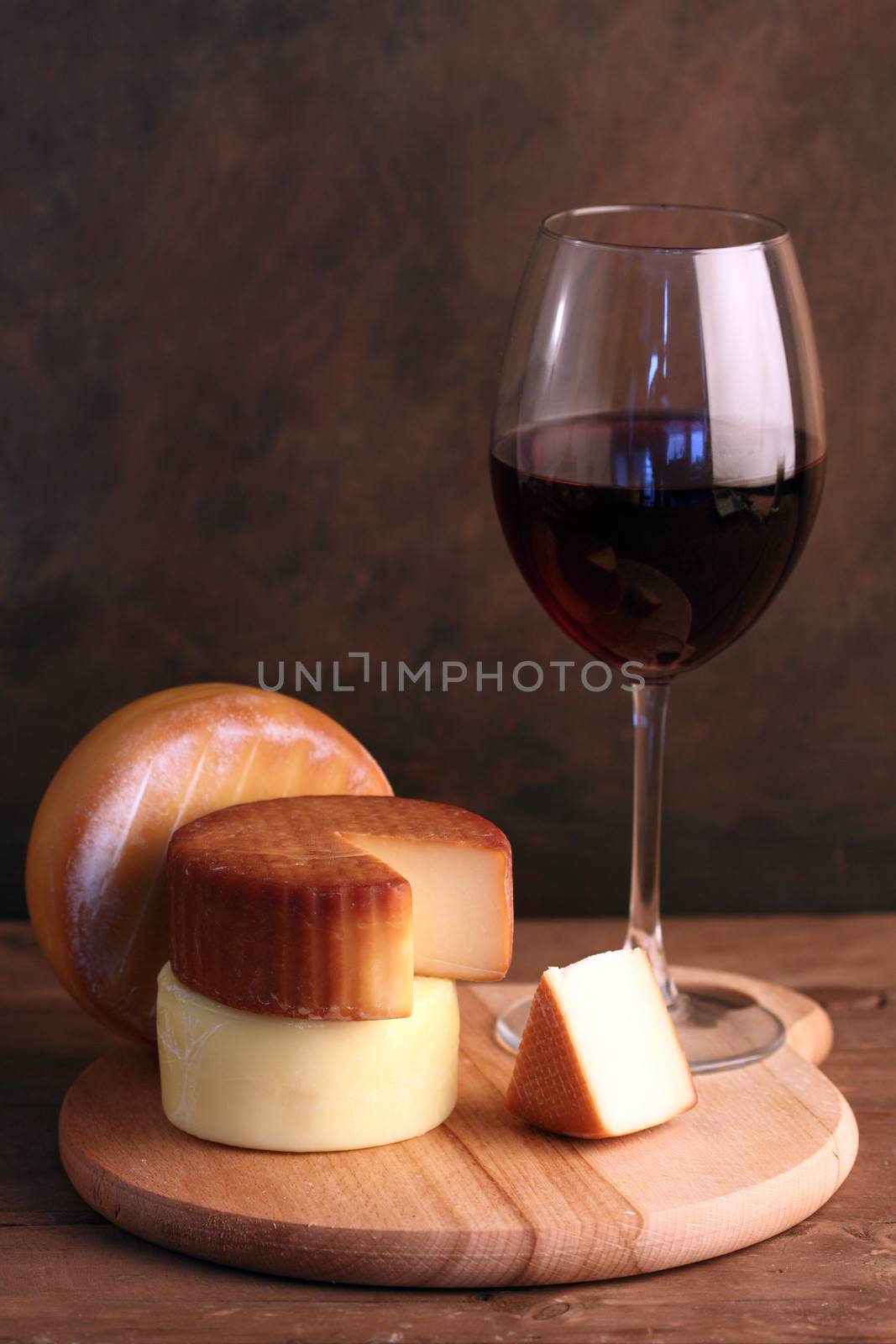 several kinds of cheese and a glass of red wine
