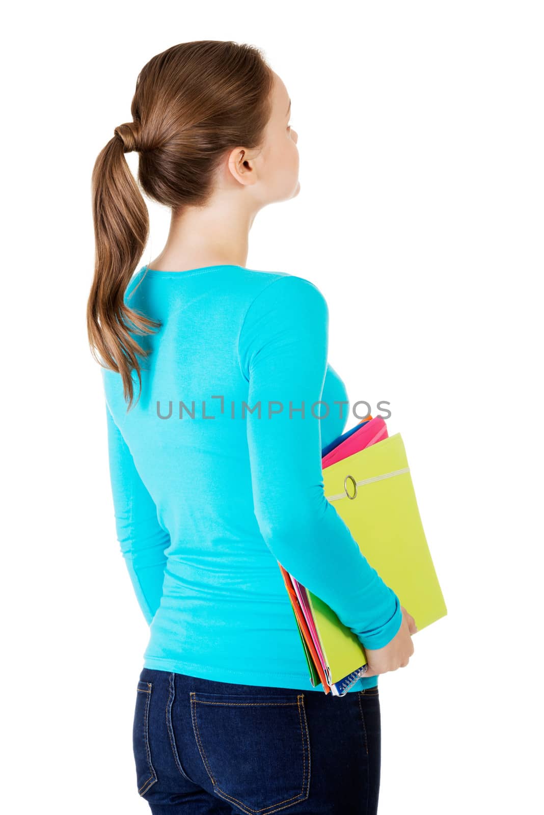 Attractive young woman holding files looking up. Isolated on white.