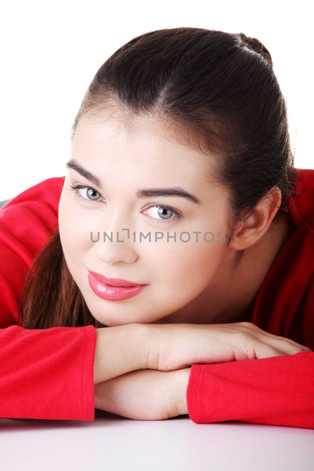 Happy casual woman's portrait while lying. isolated on white.