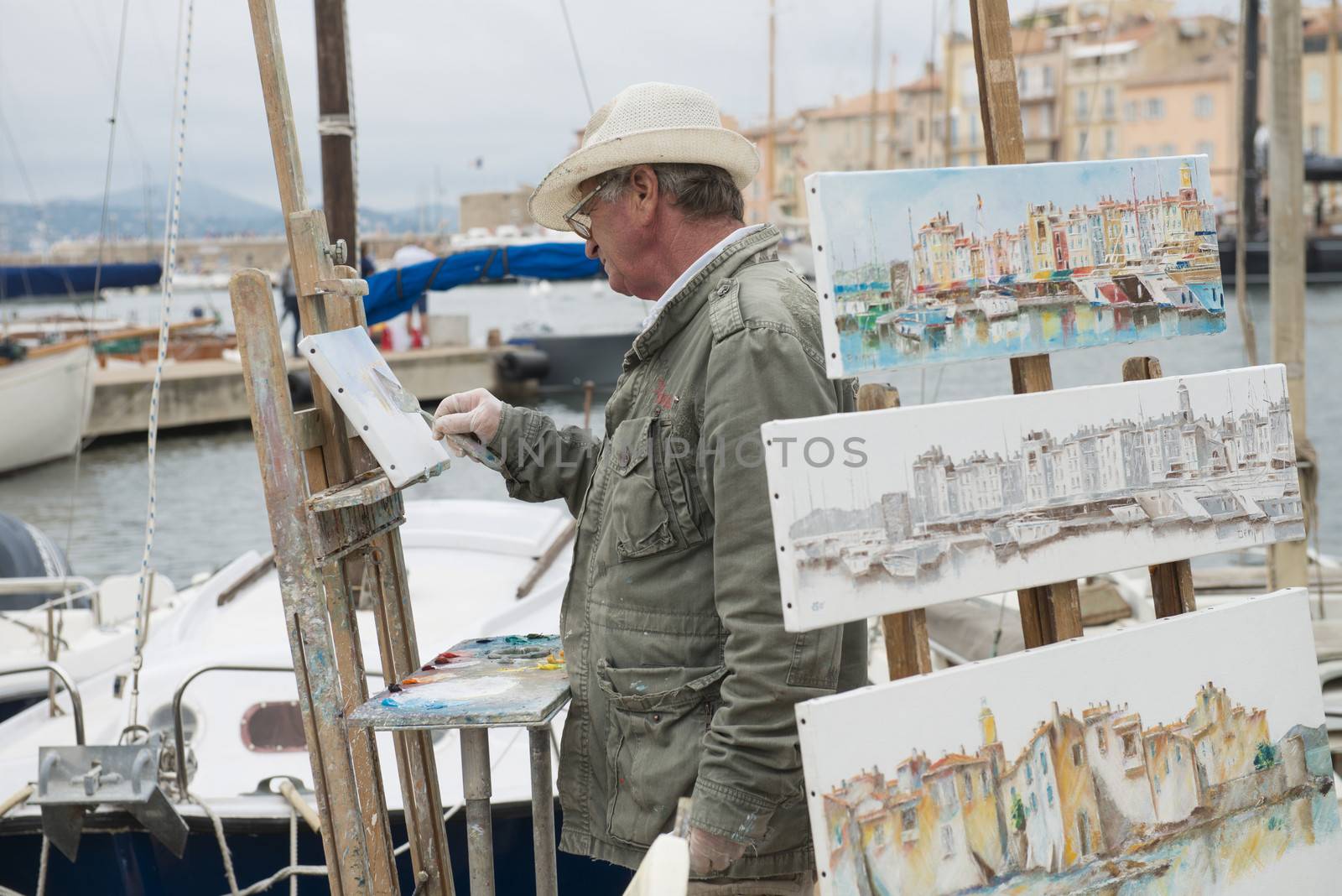 Saint Tropez, France - October 21, 2013: Street artist in Saint Tropez was painting and selling his work along the habour. 