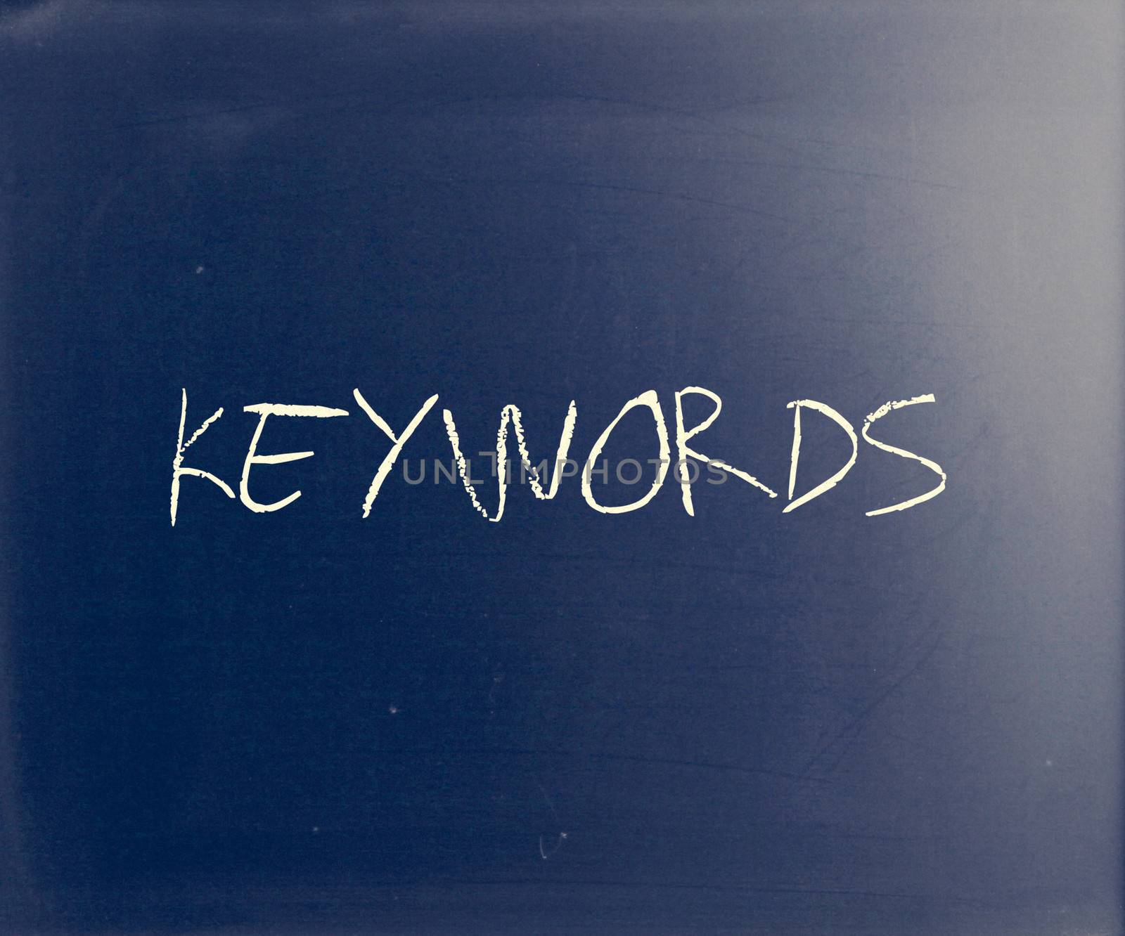 "Keywords" handwritten with white chalk on a blackboard.