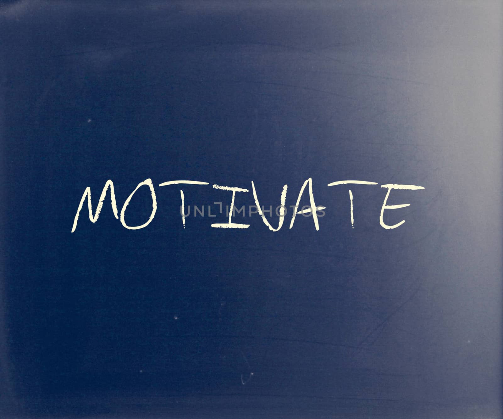 "Motivate" handwritten with white chalk on a blackboard.