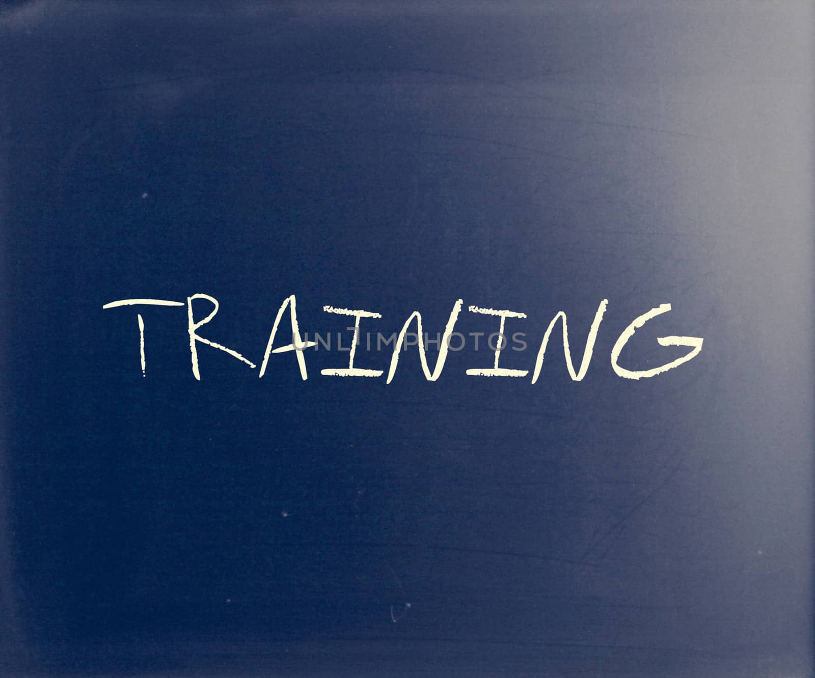 "Training" handwritten with white chalk on a blackboard.