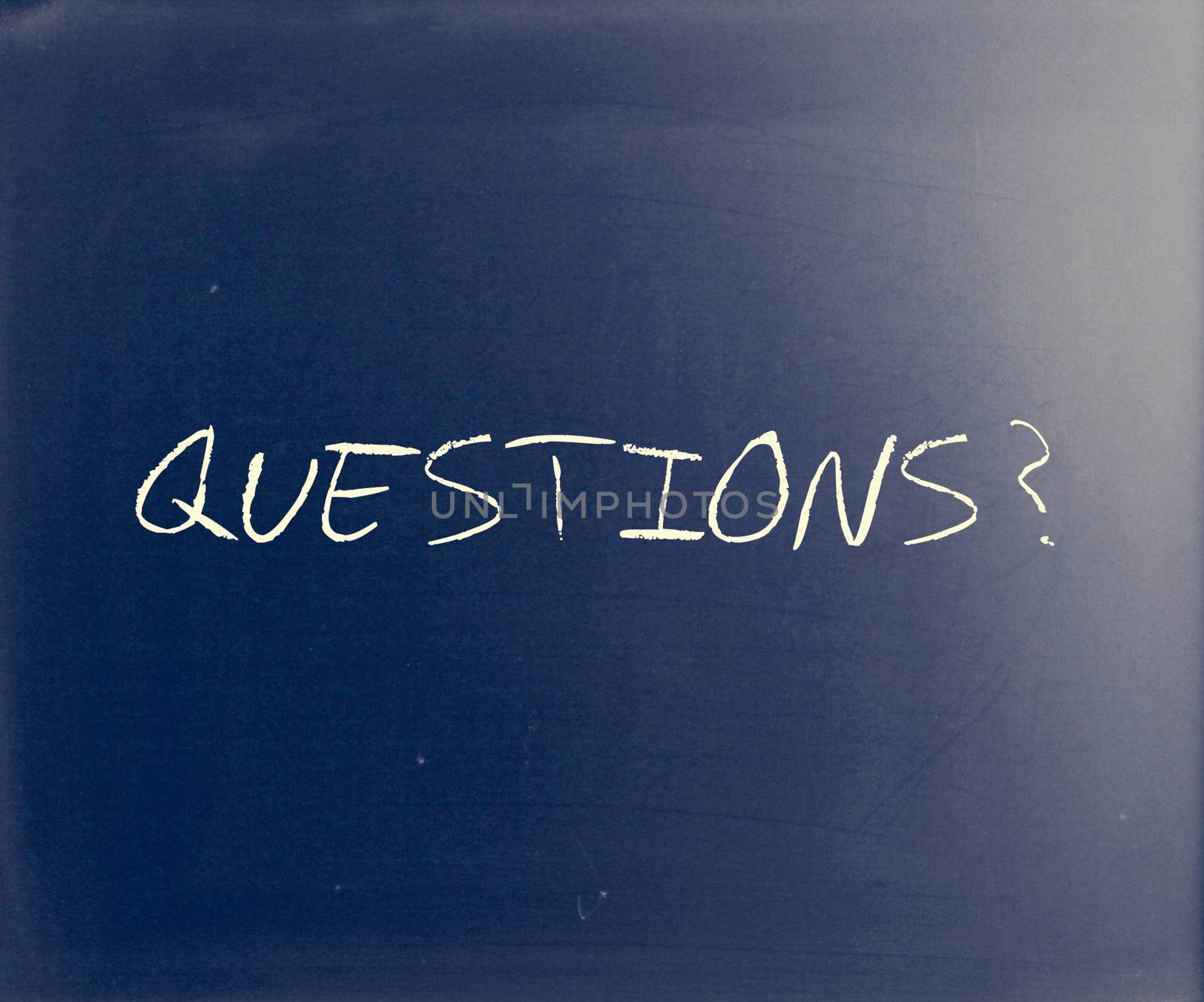 "Questions?" handwritten with white chalk on a blackboard by nenov