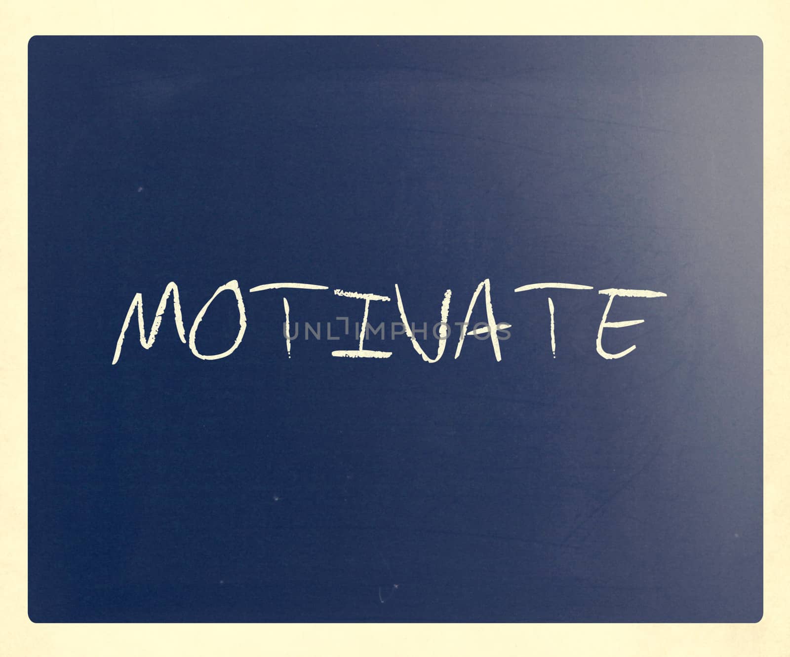 "Motivate" handwritten with white chalk on a blackboard.