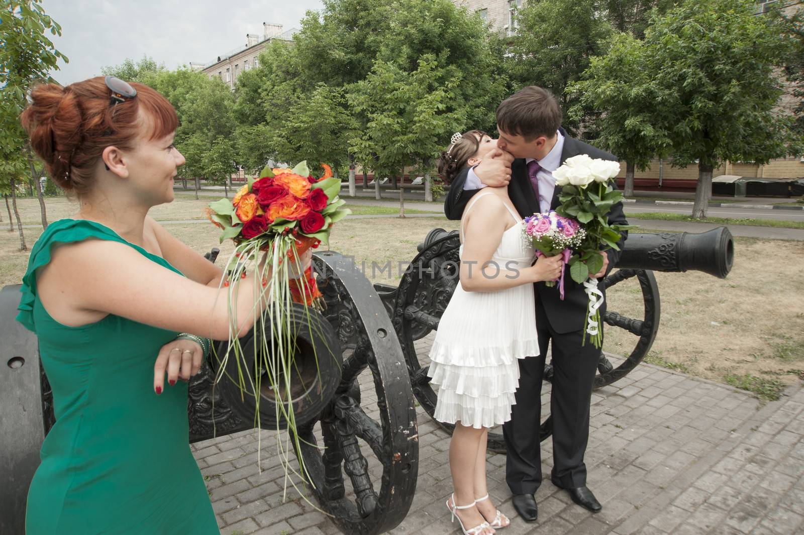 Moscow, Russia - July 10 2010. Traditional Russian weddind. The girlfriend of the bride looks as the groom and the bride make kiss.