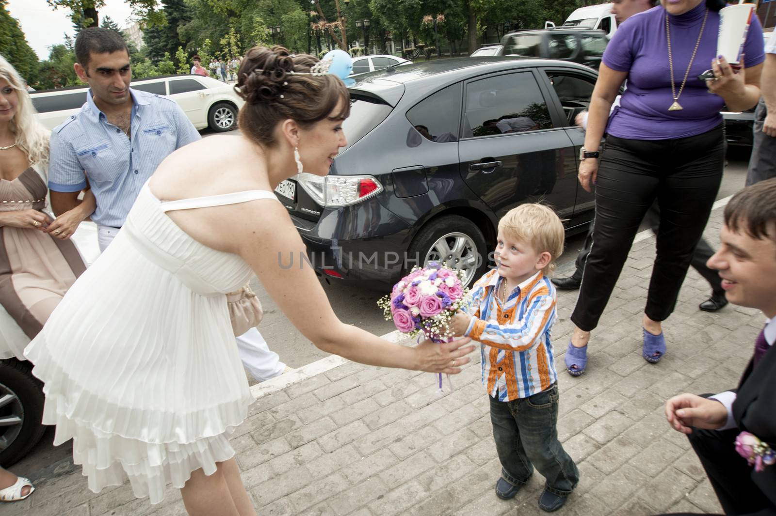 Moscow, Russia - July 10 2010. Traditional Russian weddind. The little boy congratulates on wedding and gives flowers to the bride