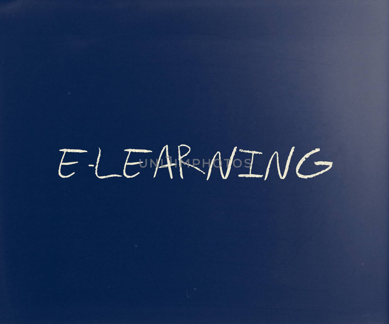 "E-learning" handwritten with white chalk on a blackboard by nenov