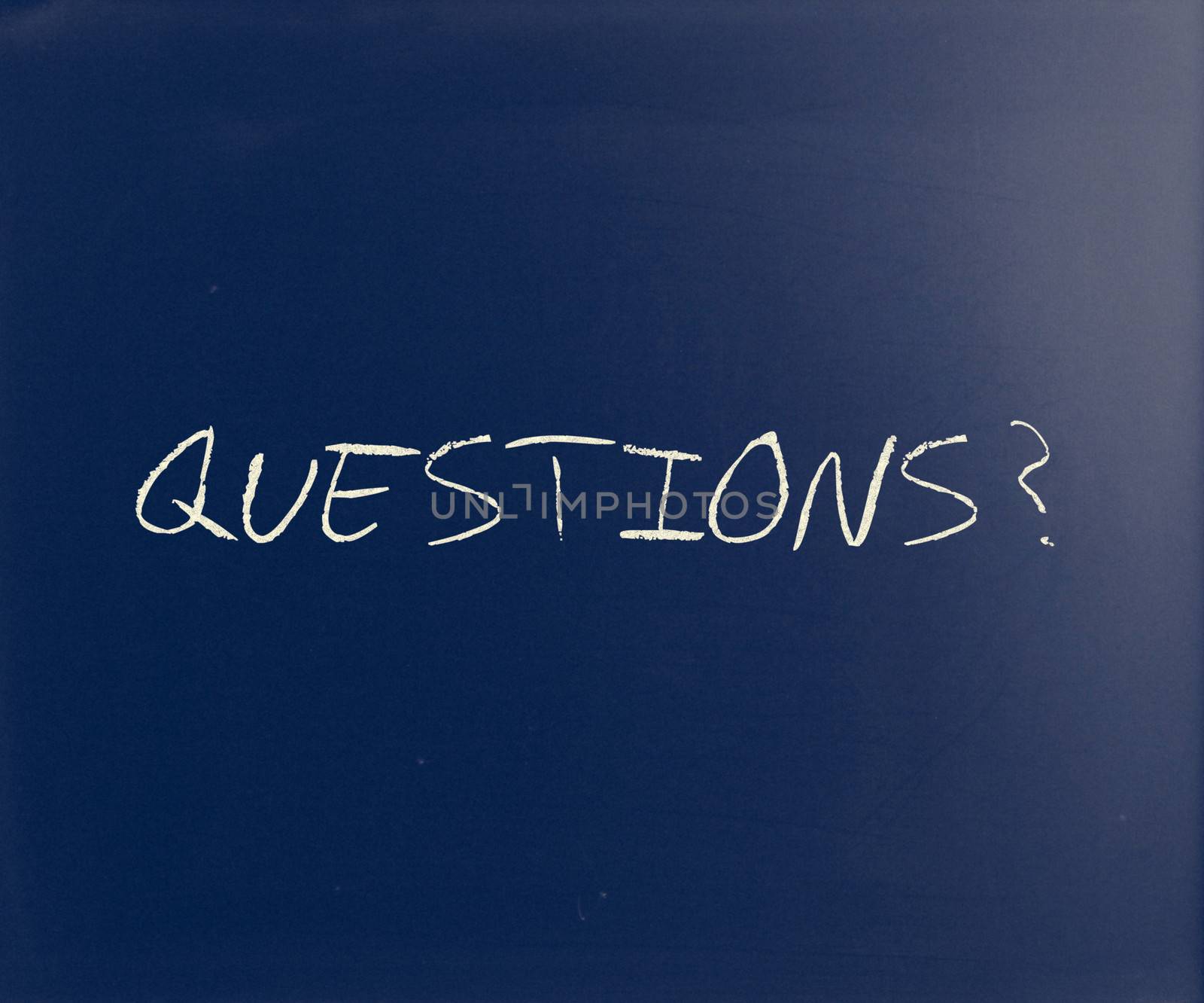 "Questions?" handwritten with white chalk on a blackboard.