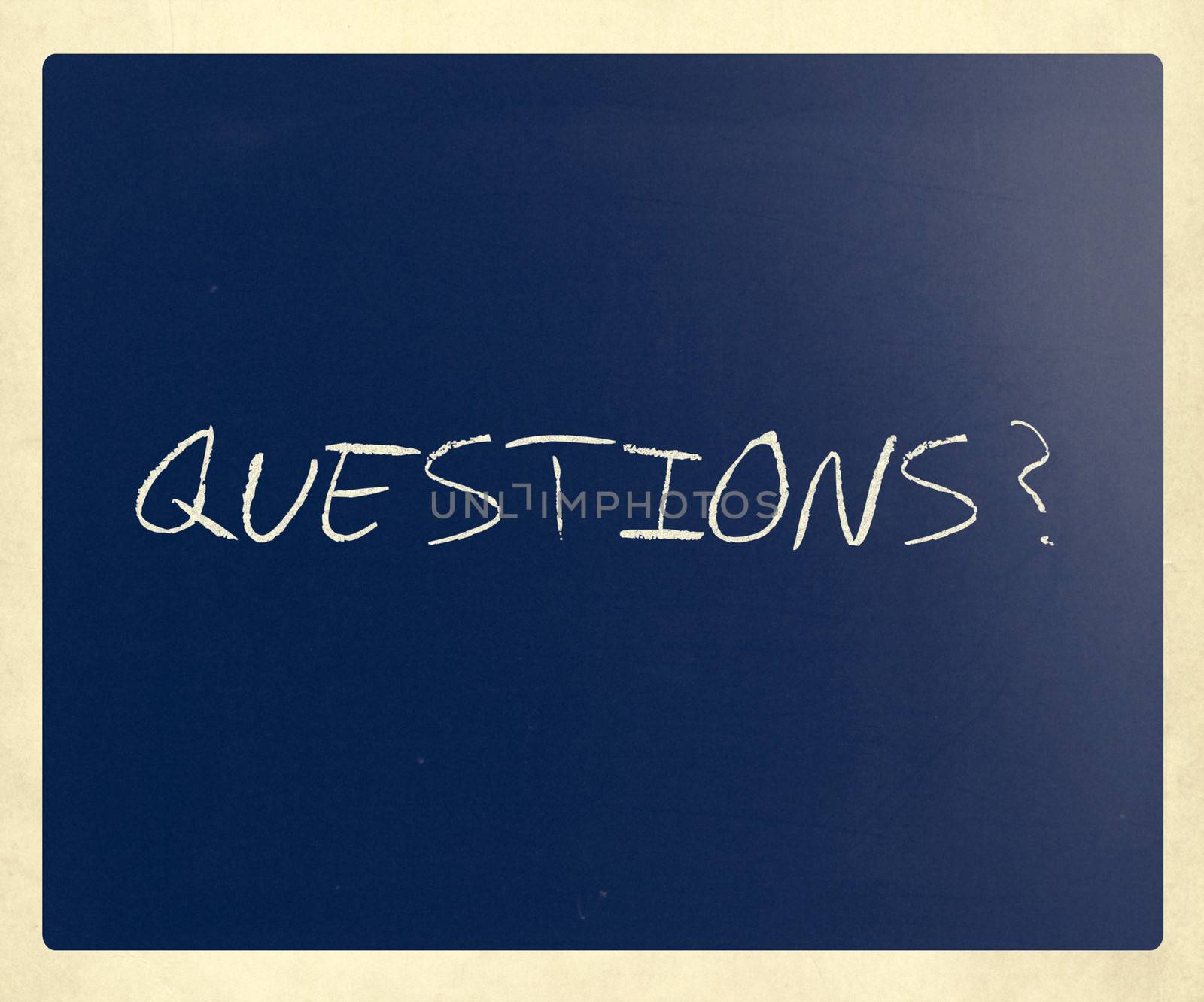 "Questions?" handwritten with white chalk on a blackboard.
