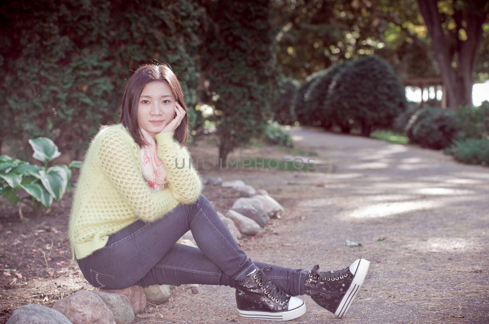 Young woman sitting next to a road looking happy