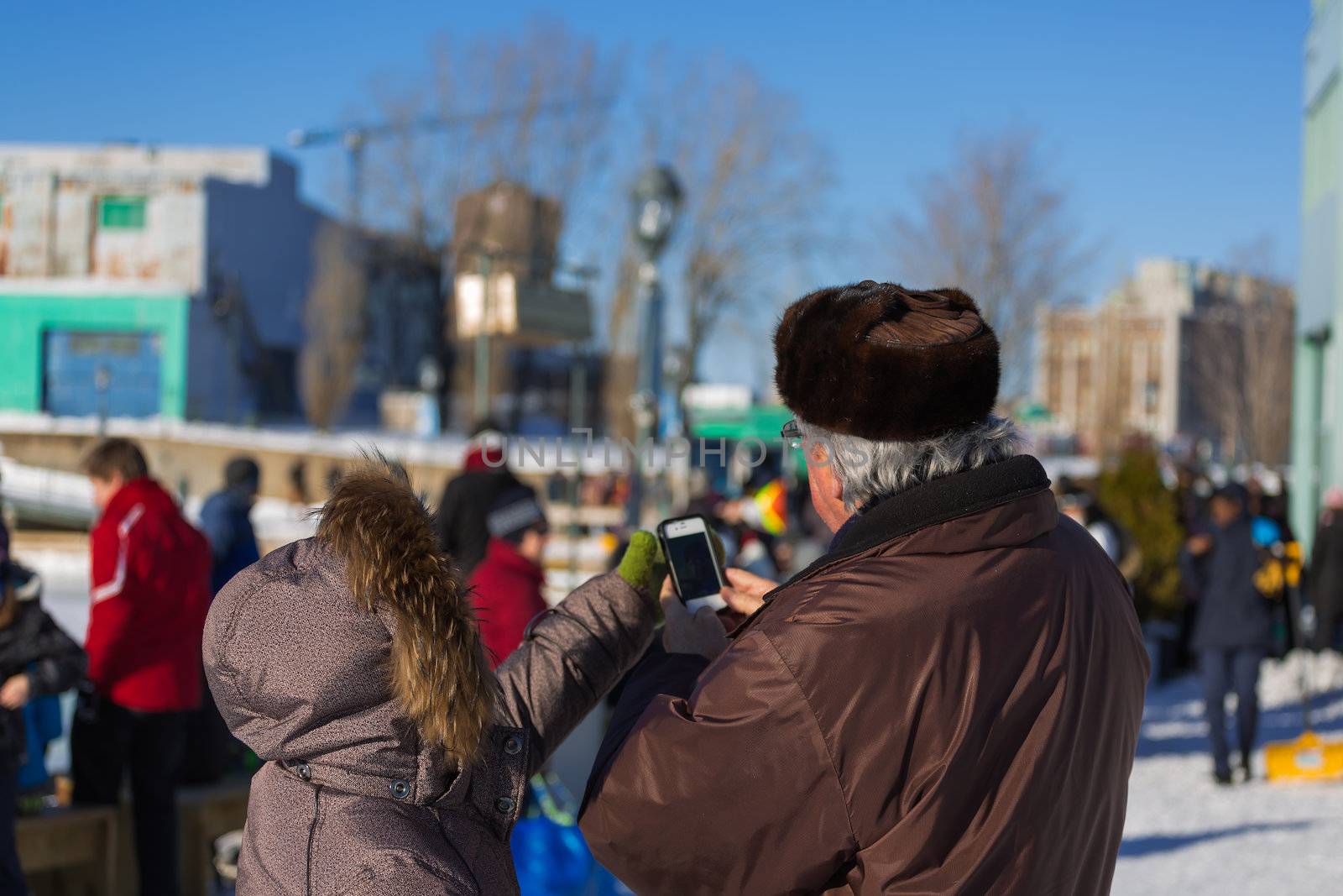 A senior trying to take a picture of the Skating Rink in Old Port of Montreal, Quebec ,Canada