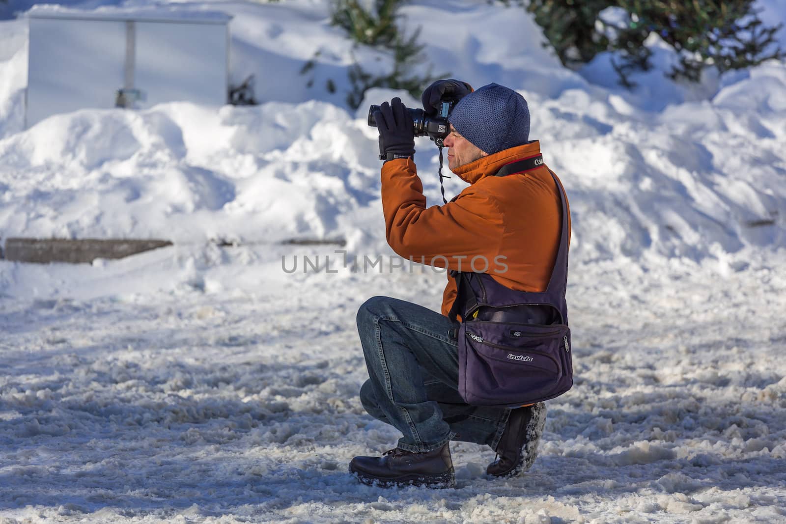 An experienced photographer in taking a picture of something in a cold winter day in Old Montreal, Quebec, Canada