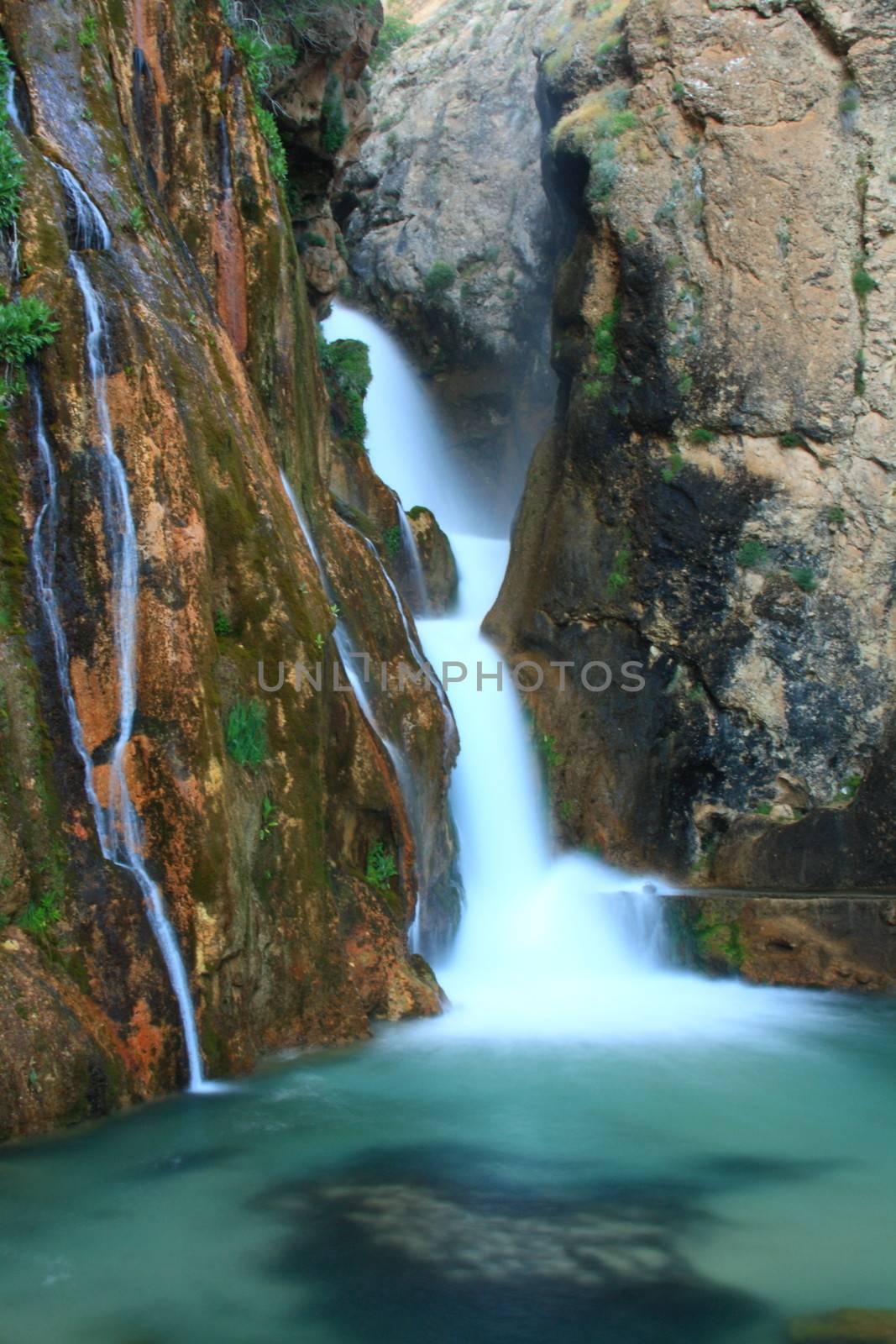 water falling to river between huge rocks 