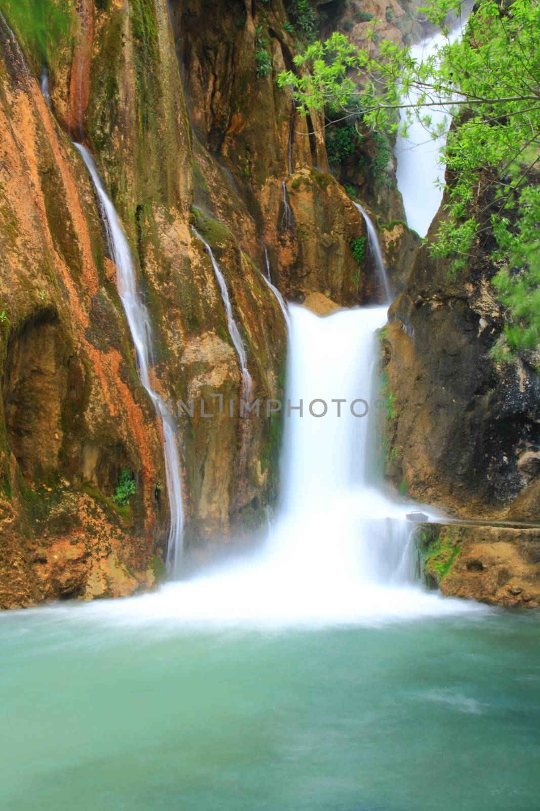 water falling to river between huge rocks 