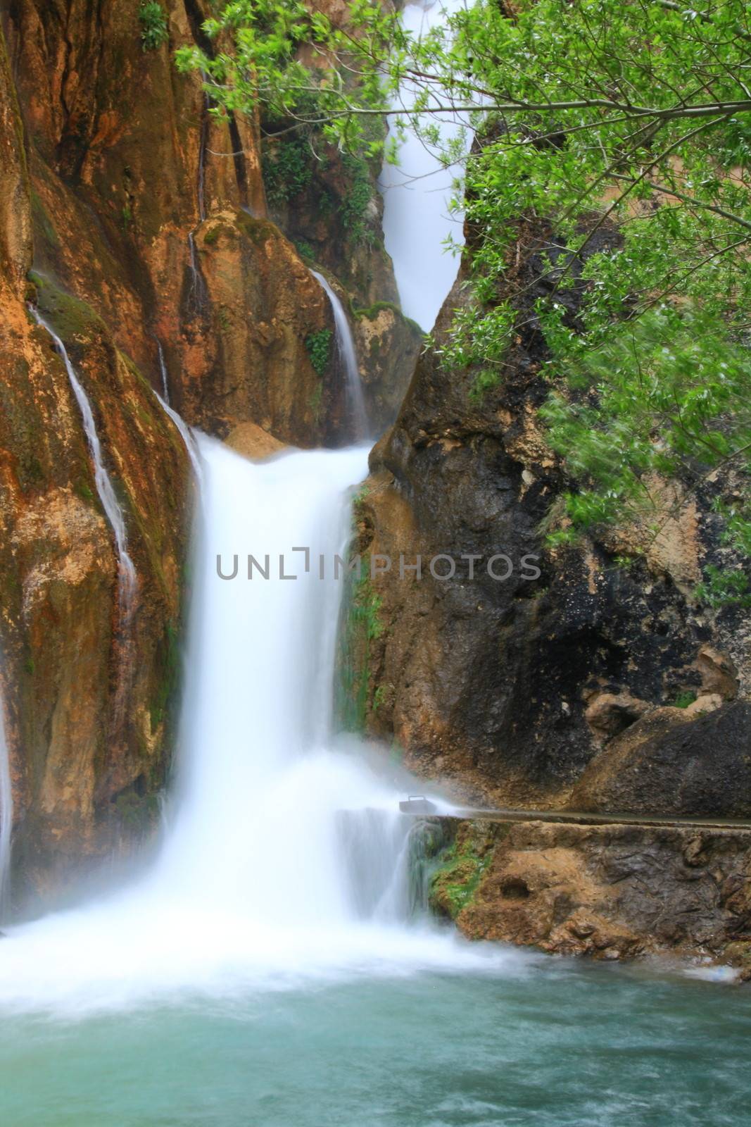 water falling to river between huge rocks 