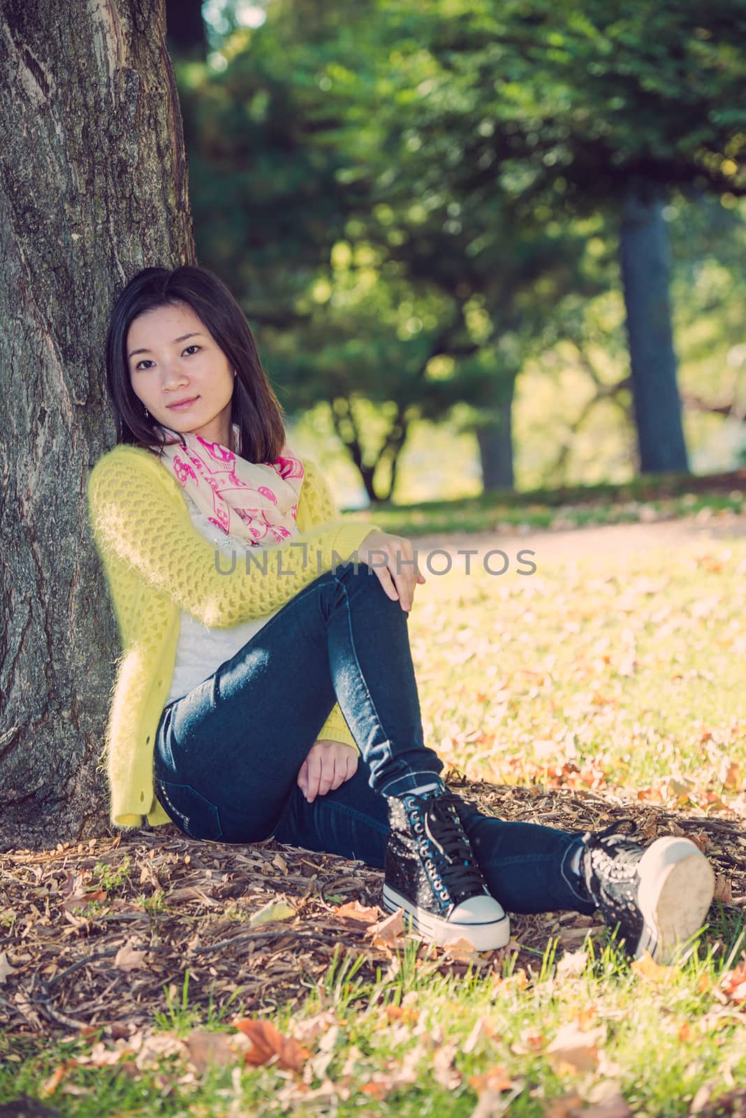 Portrait of happy looking woman sitting against a tree