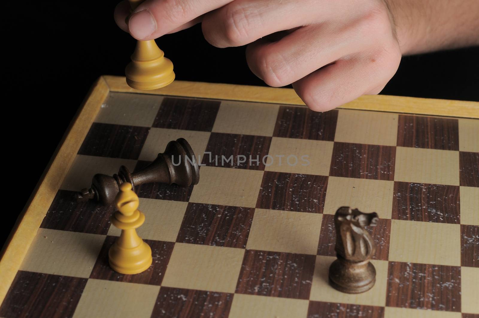 One Left Male Hand Playing Chess on a Black Background