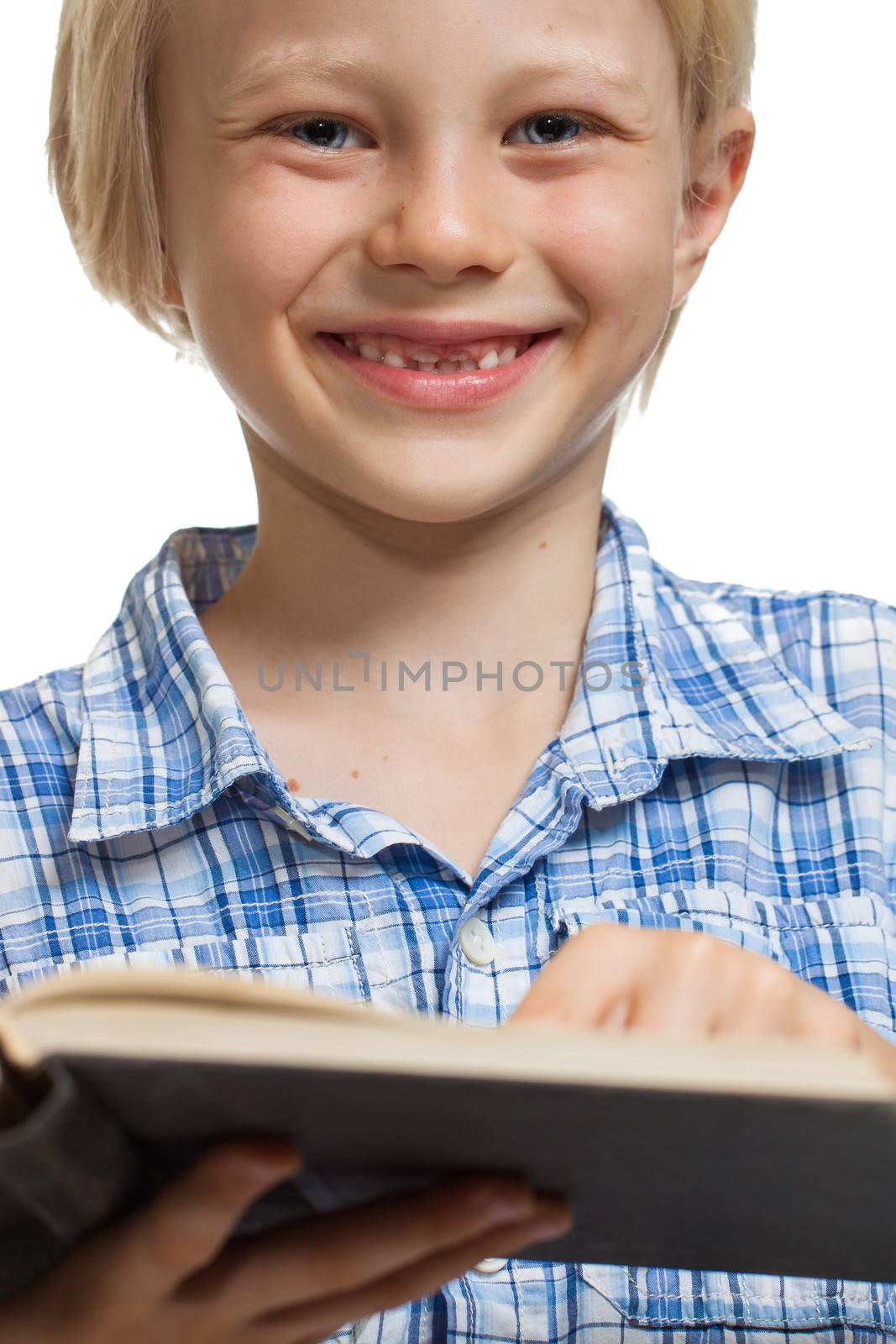 Close-up of a  happy young boy holding and reading a thick book. Isolated on white.