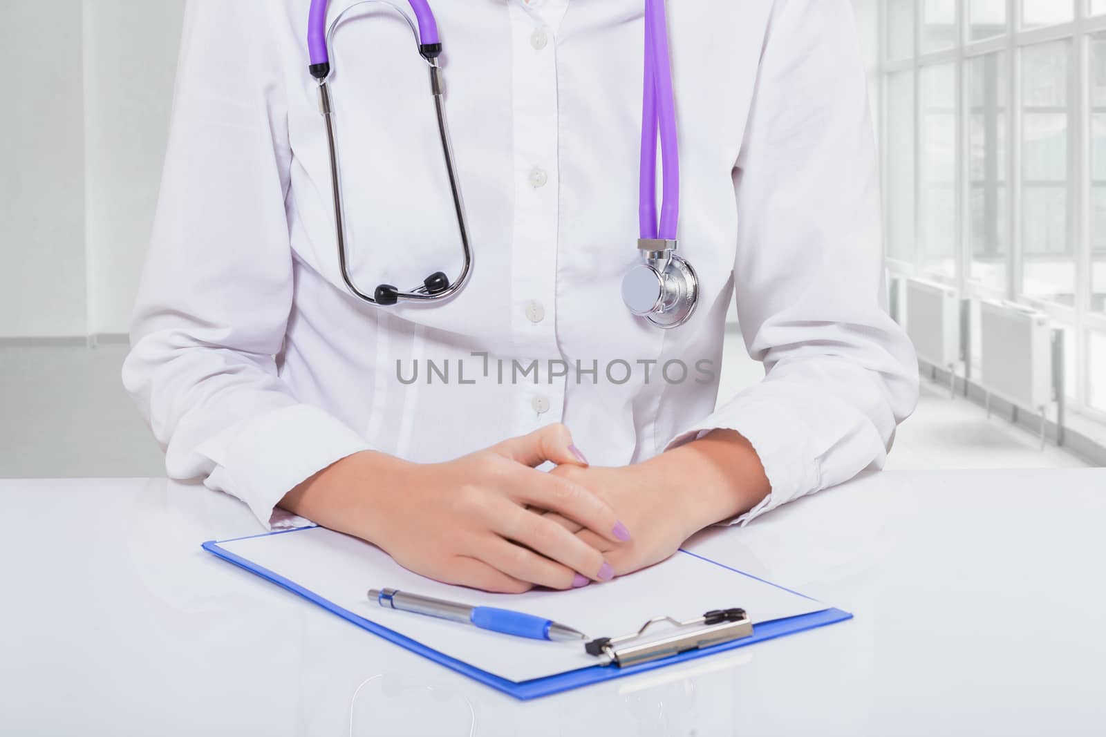 hands of female doctor on clipboard