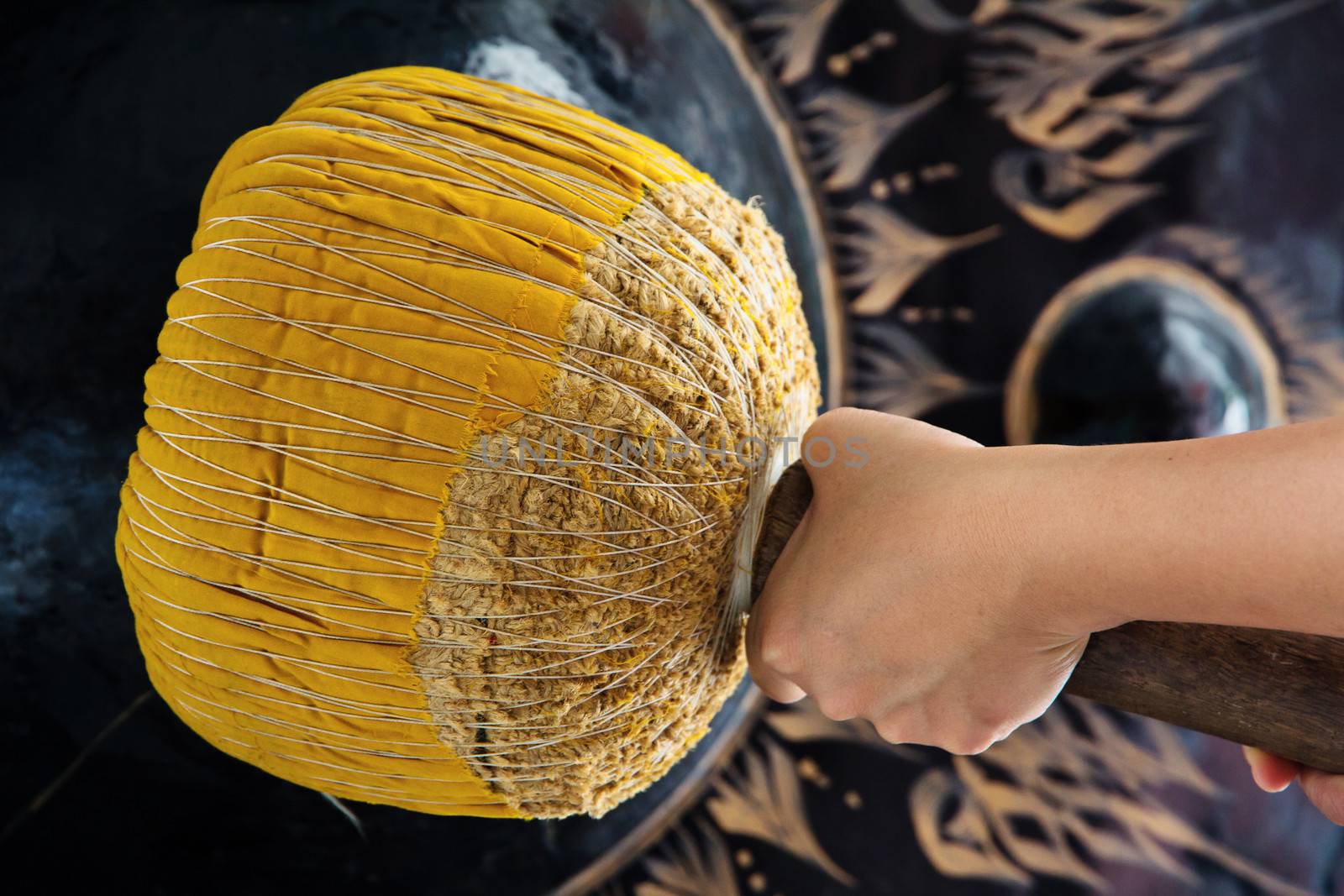 Hand hit big gong in temple