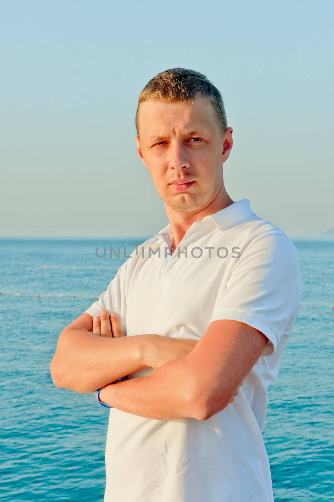 portrait of a man in a white shirt against the sea