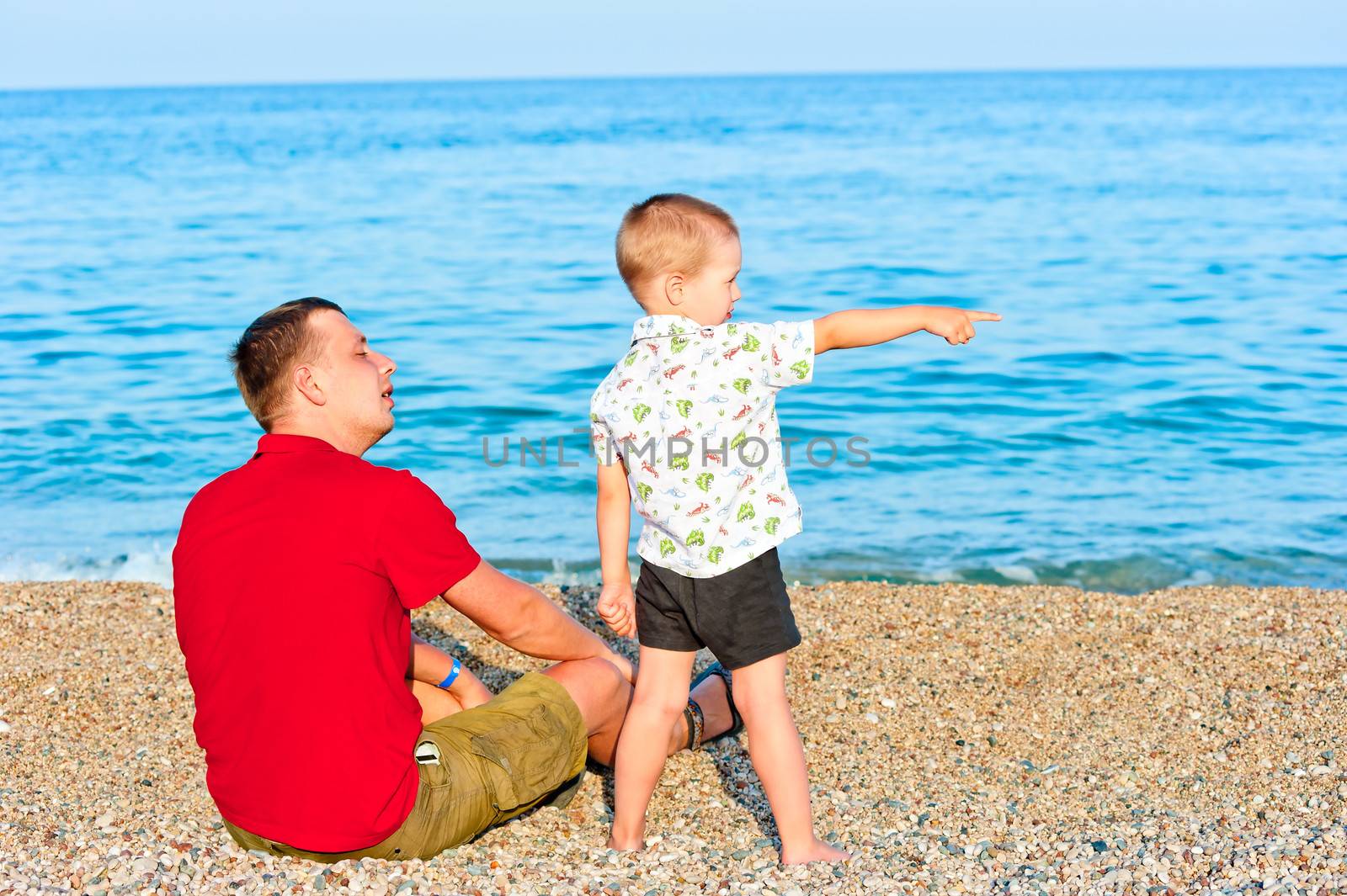 son standing next to his father, and that it shows him in the sea