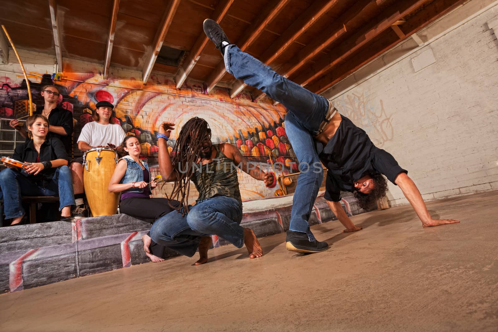 Group of six capoeira performers in urban building