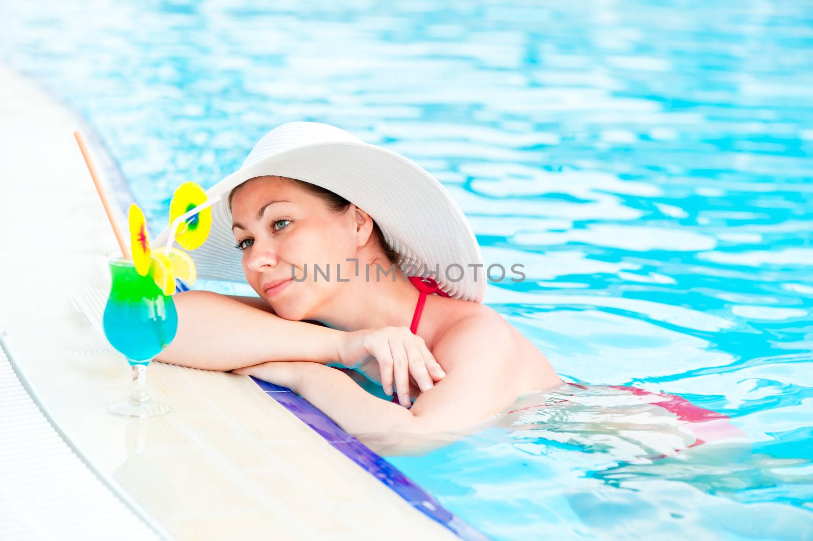 Woman in bikini and hat in the pool