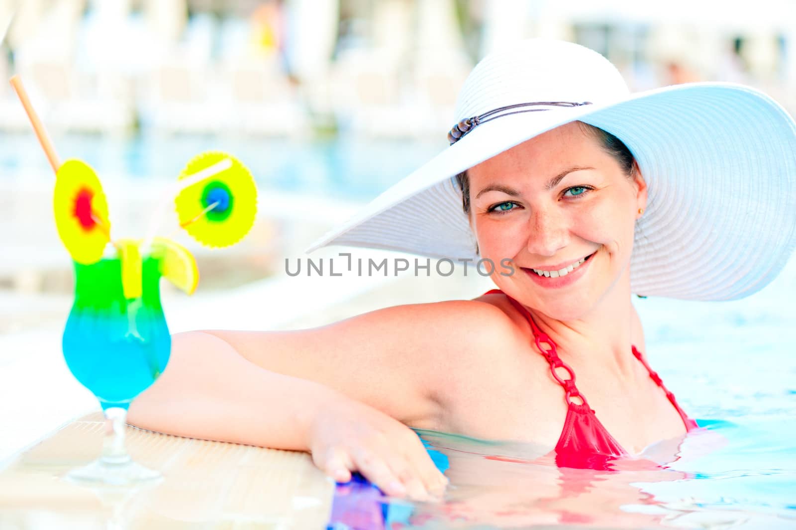 girl in the pool in a white hat smiling