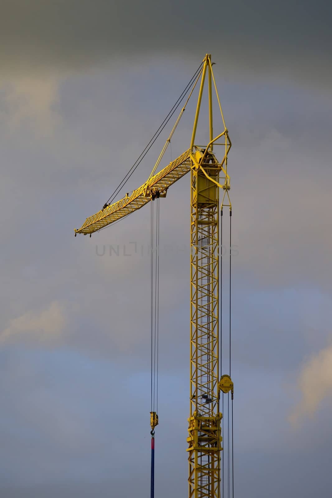 Tower crane against dark, stormy sky