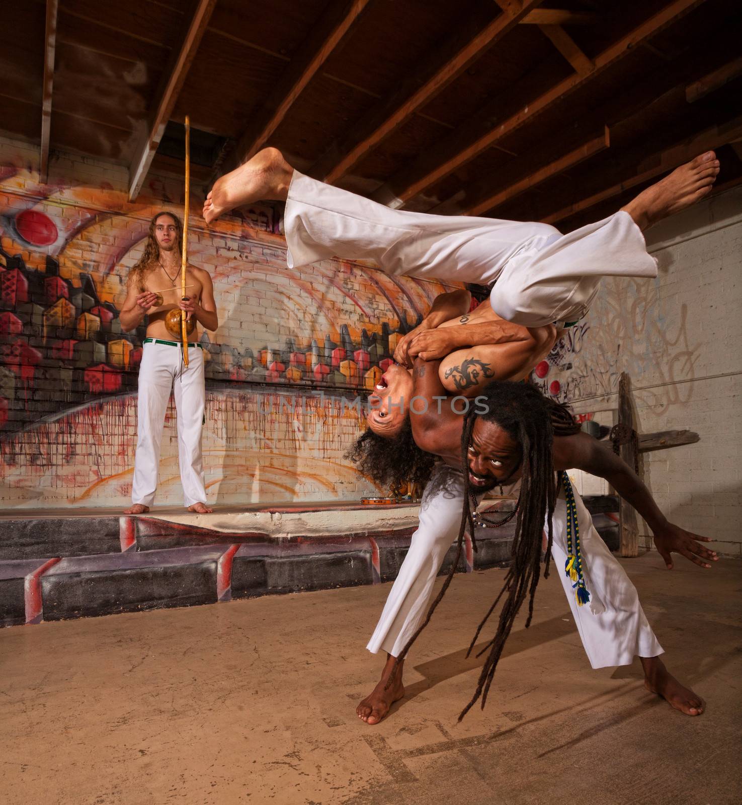 Capoeira man throwing partner over his shoulders