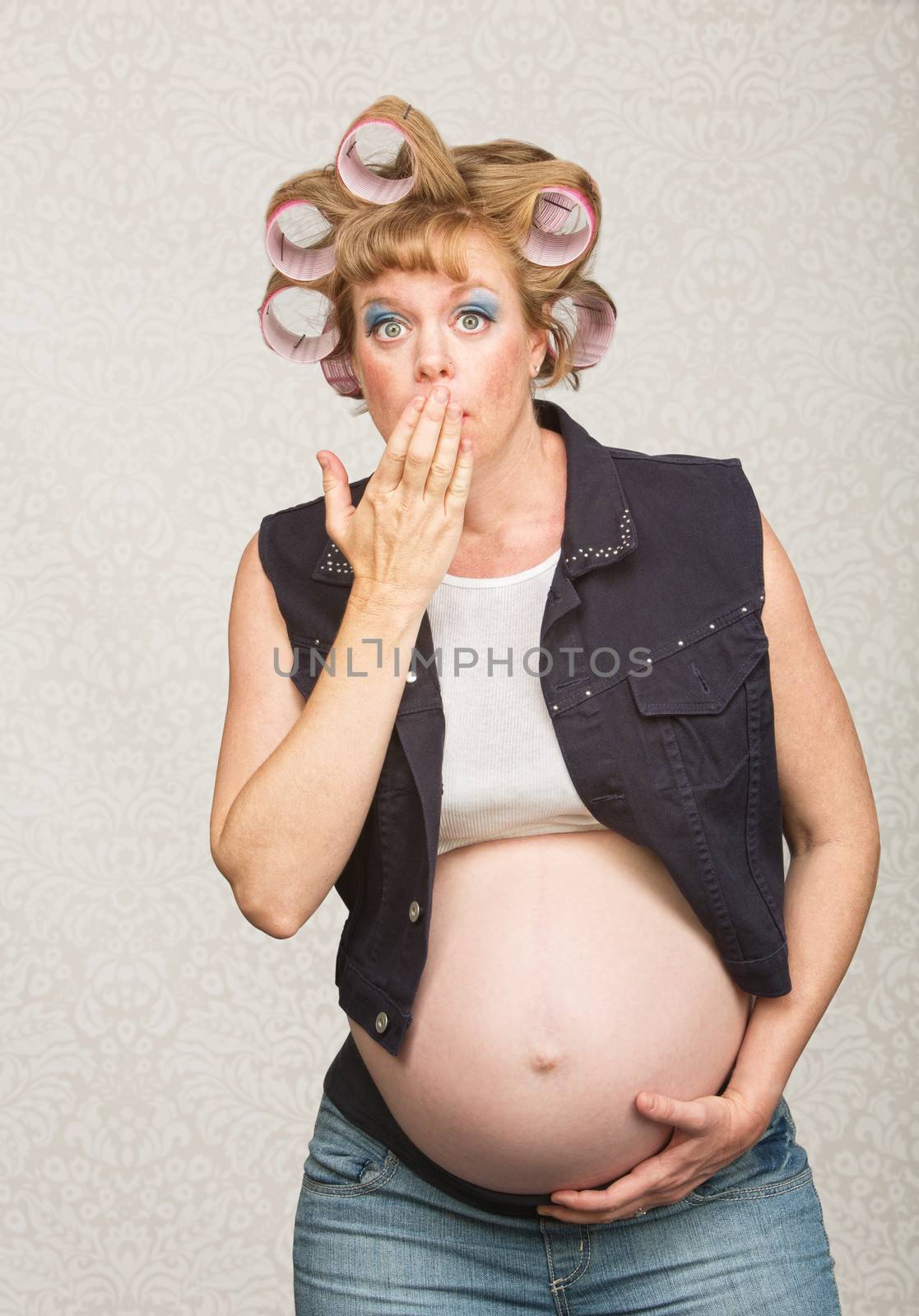 Embarrassed young pregnant single female in blue jeans