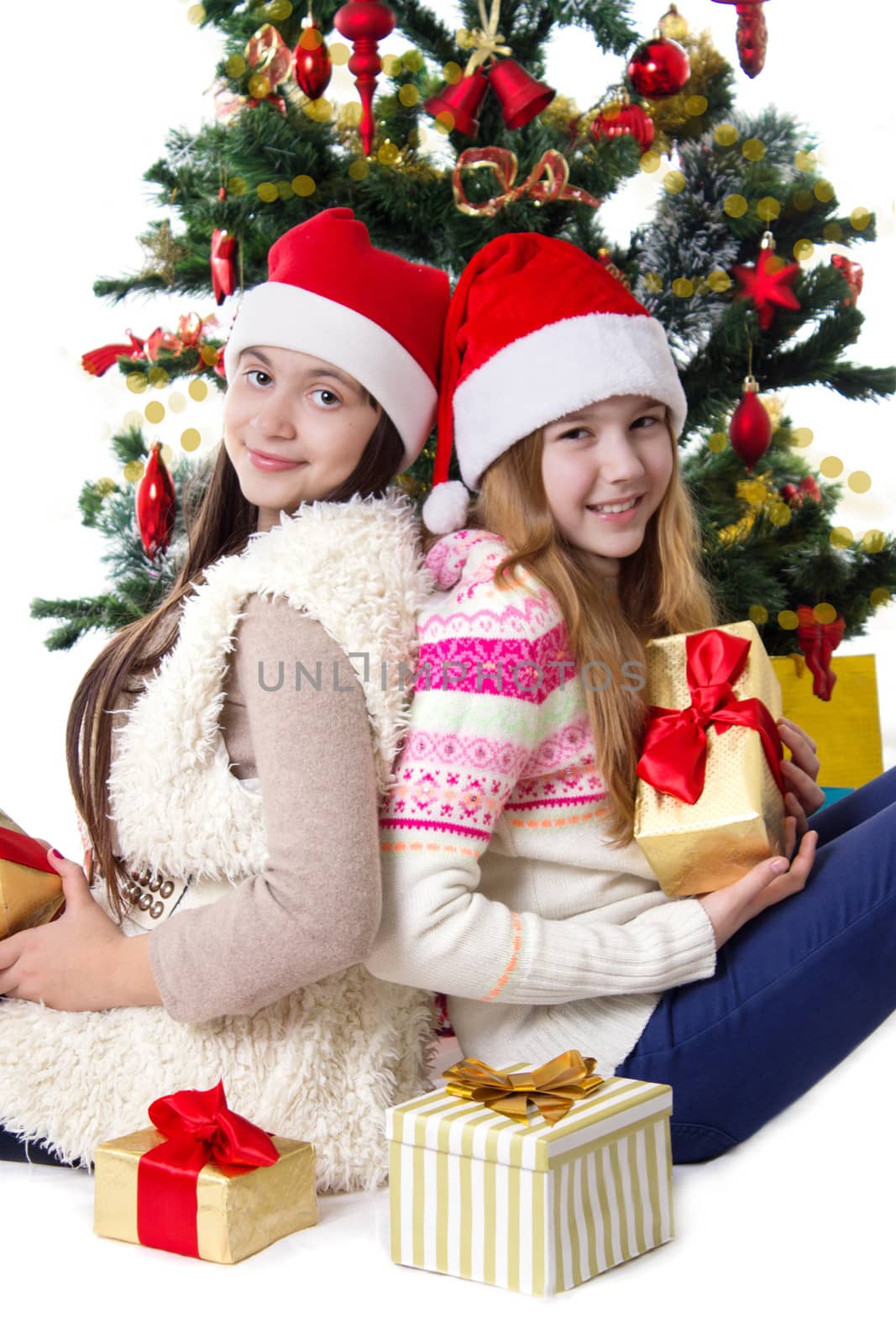 Sisters with gifts under Christmas tree by Angel_a